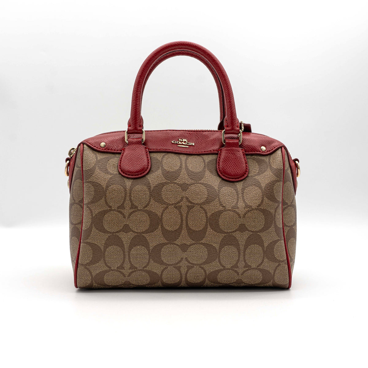 Coach Mini Bennett Boston bag in signature beige canvas with red leather trim, shown with detachable crossbody strap.