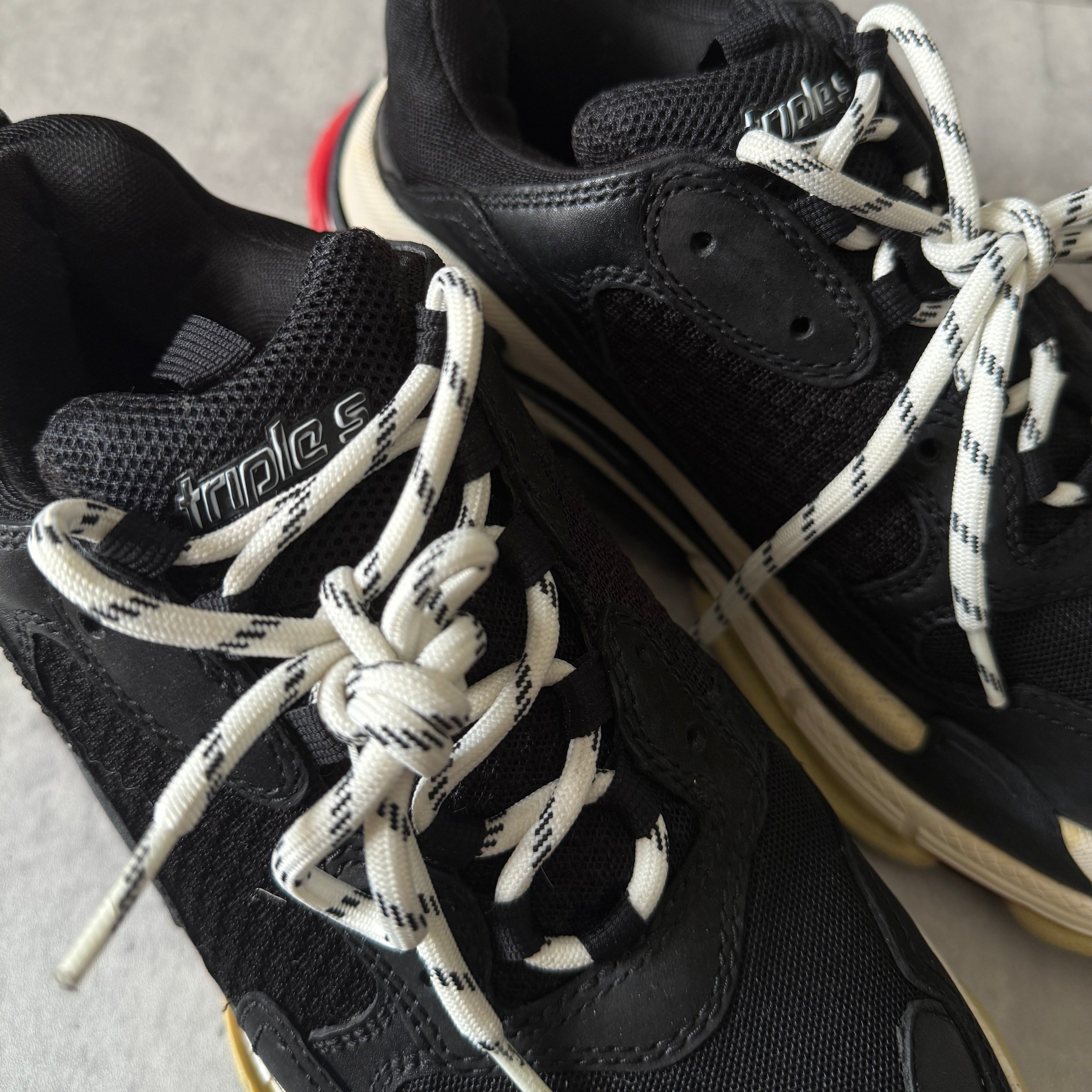 Balenciaga Triple S Black White Red sneakers, featuring layered mesh and leather upper, distressed sole, and oversized silhouette with embroidered size 42.