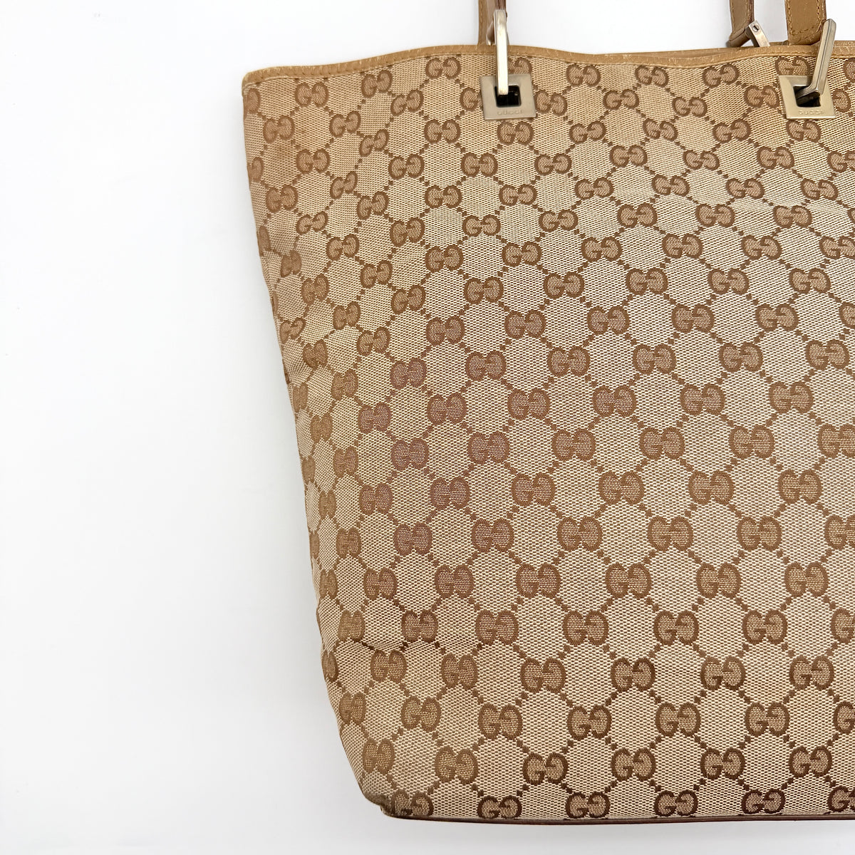Front-facing Gucci GG Monogram Tote Bag in beige canvas with brown leather trim and double handles.