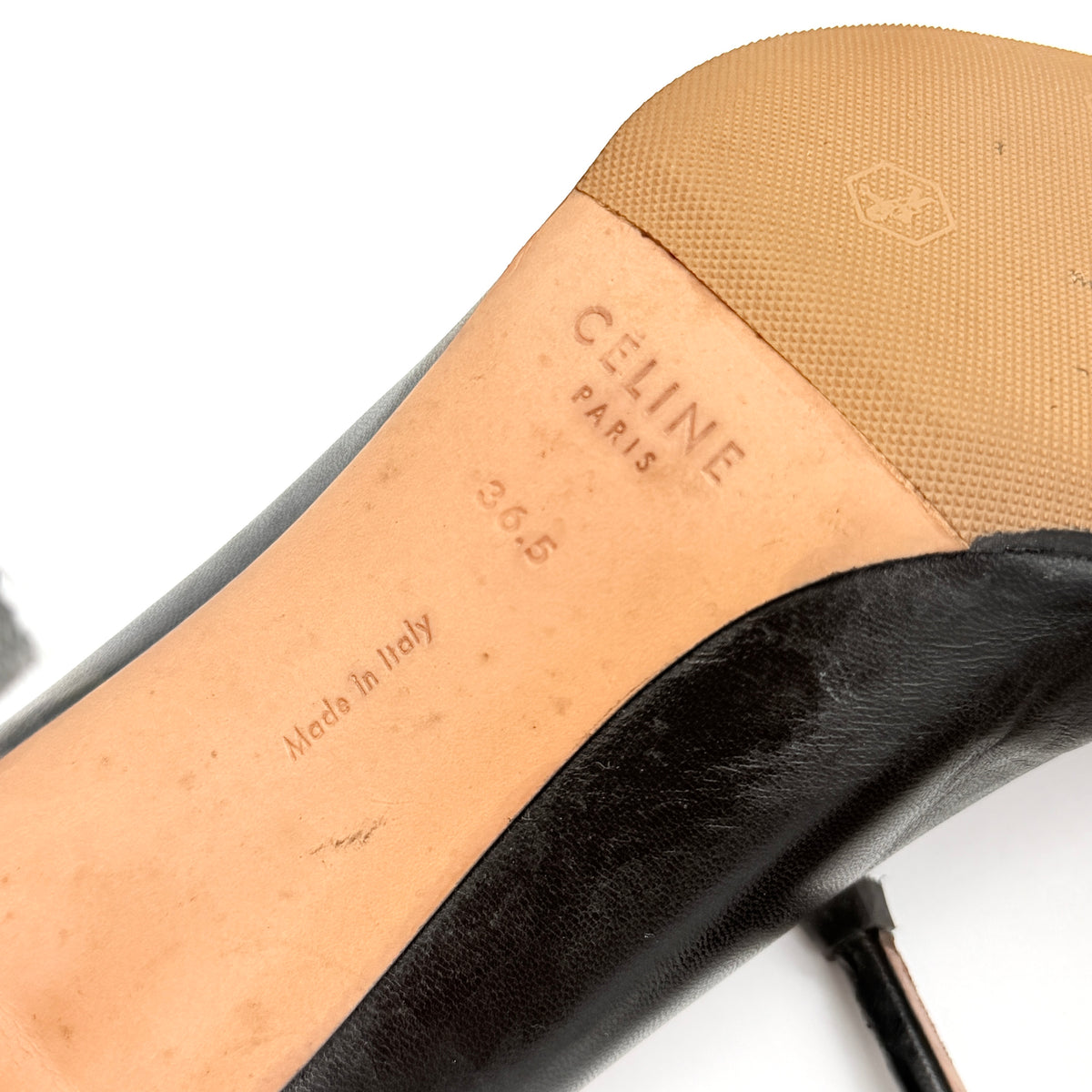 A pair of black leather Celine stiletto heels with pointed toes and burgundy insoles, shown in a softly lit studio setting.