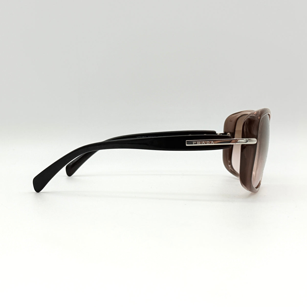 Prada SPR080 sunglasses featuring a brown and blush oversized frame with gradient lenses and silver hardware at the temples.