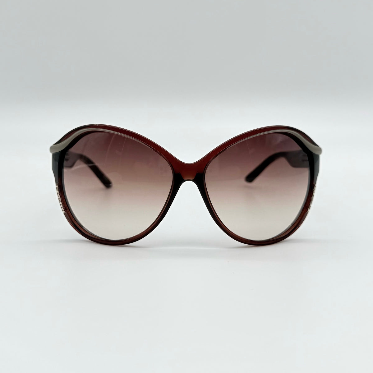 Diesel DS0094 sunglasses in gradient brown with oversized round lenses, shown with branded case and cleaning cloth.