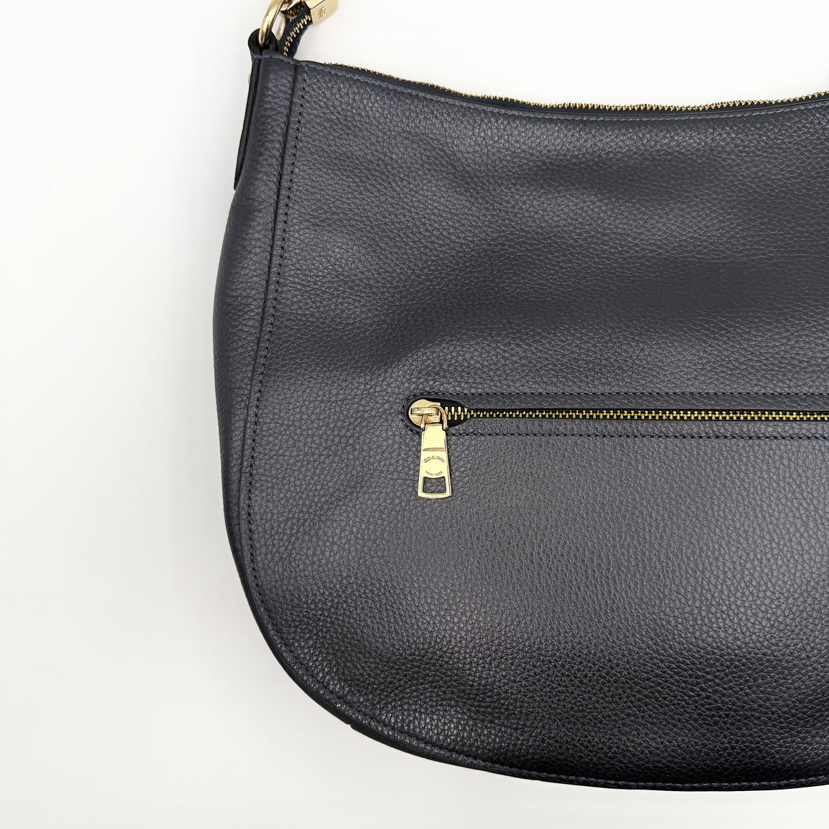 Coach Elle Hobo bag in navy blue pebbled leather with gold hardware and a detachable strap, styled on a white background.