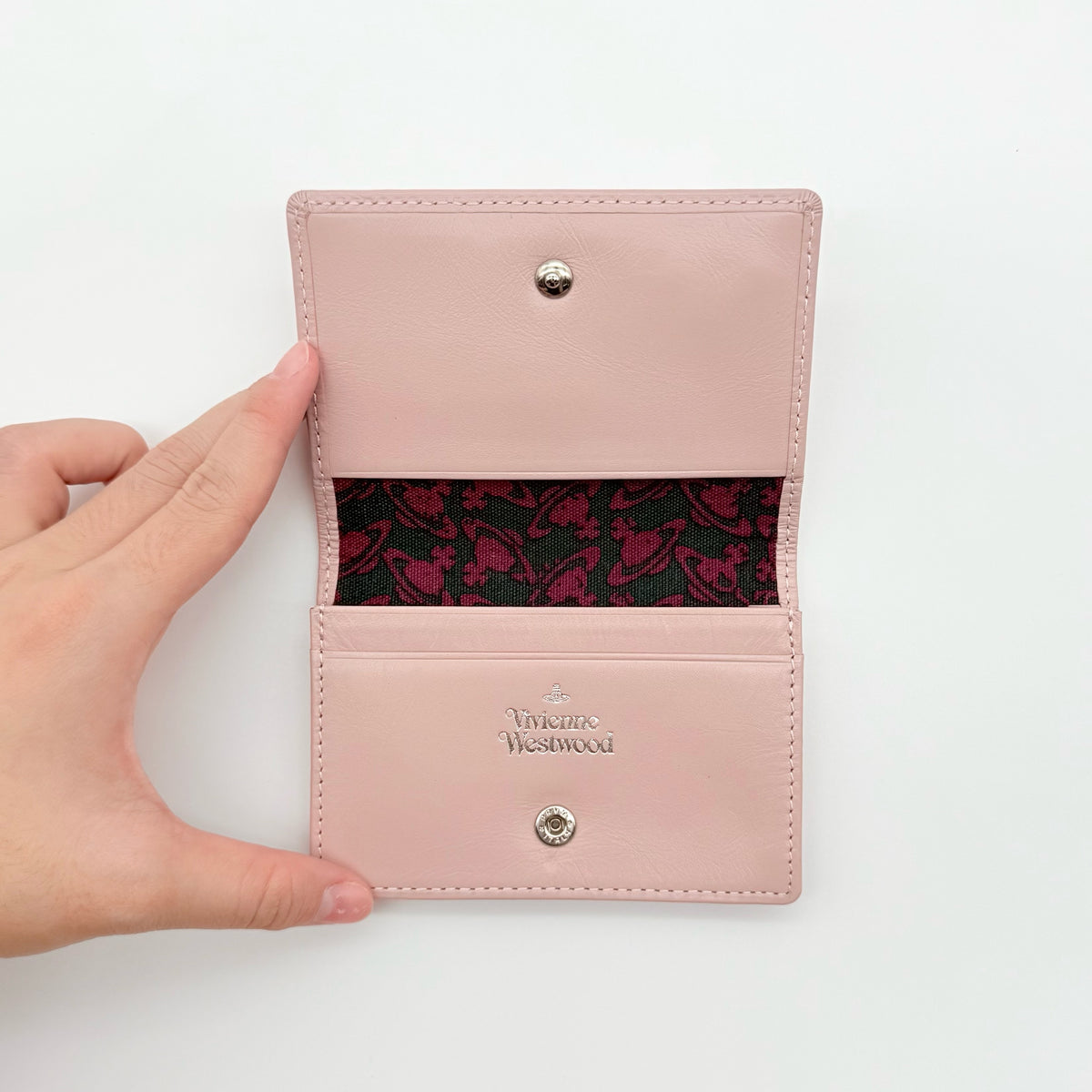 Vivienne Westwood light pink leather card case with silver-tone Orb emblem and sleek, structured design.