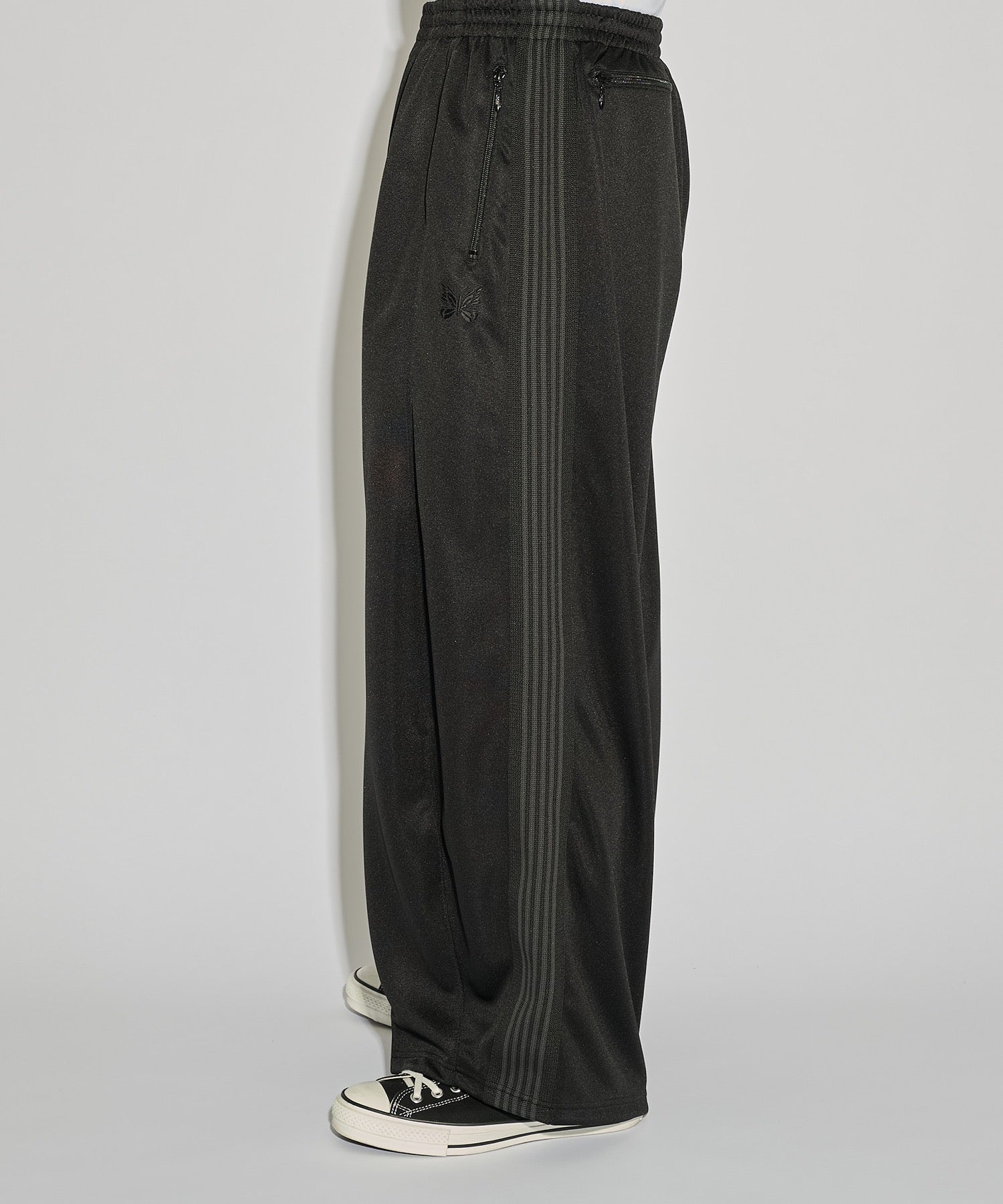 Needles H.D. Track Pant in black with tonal butterfly embroidery and relaxed wide-leg cut, photographed on model.