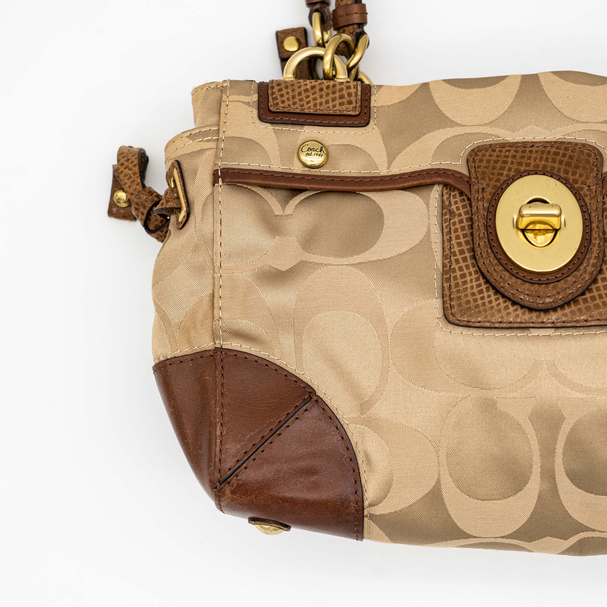Coach Signature Peyton Shoulder Bag in brown sateen and leather with gold-tone hardware and turnlock pocket, photographed on a white background.