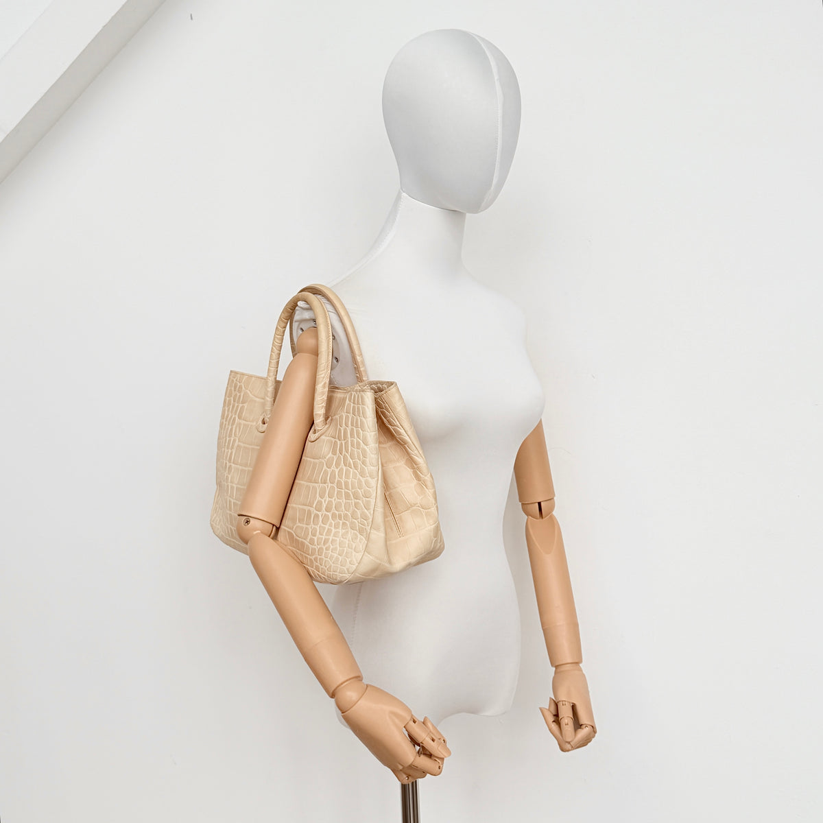 Furla beige croc-embossed leather handbag with double handles and silver-tone logo medallion, photographed on a white background.