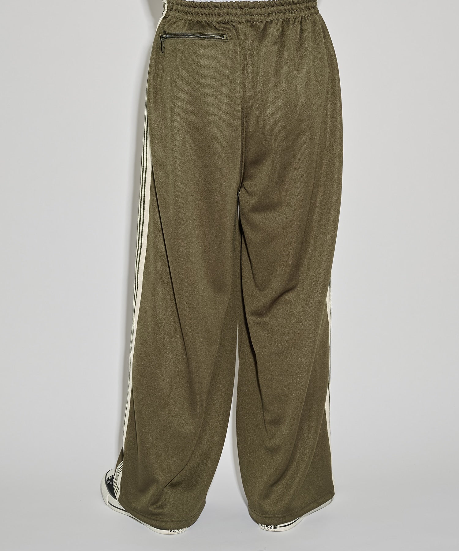 Needles H.D. Track Pant in olive green with cream stripes and butterfly logo, shown in a relaxed silhouette.
