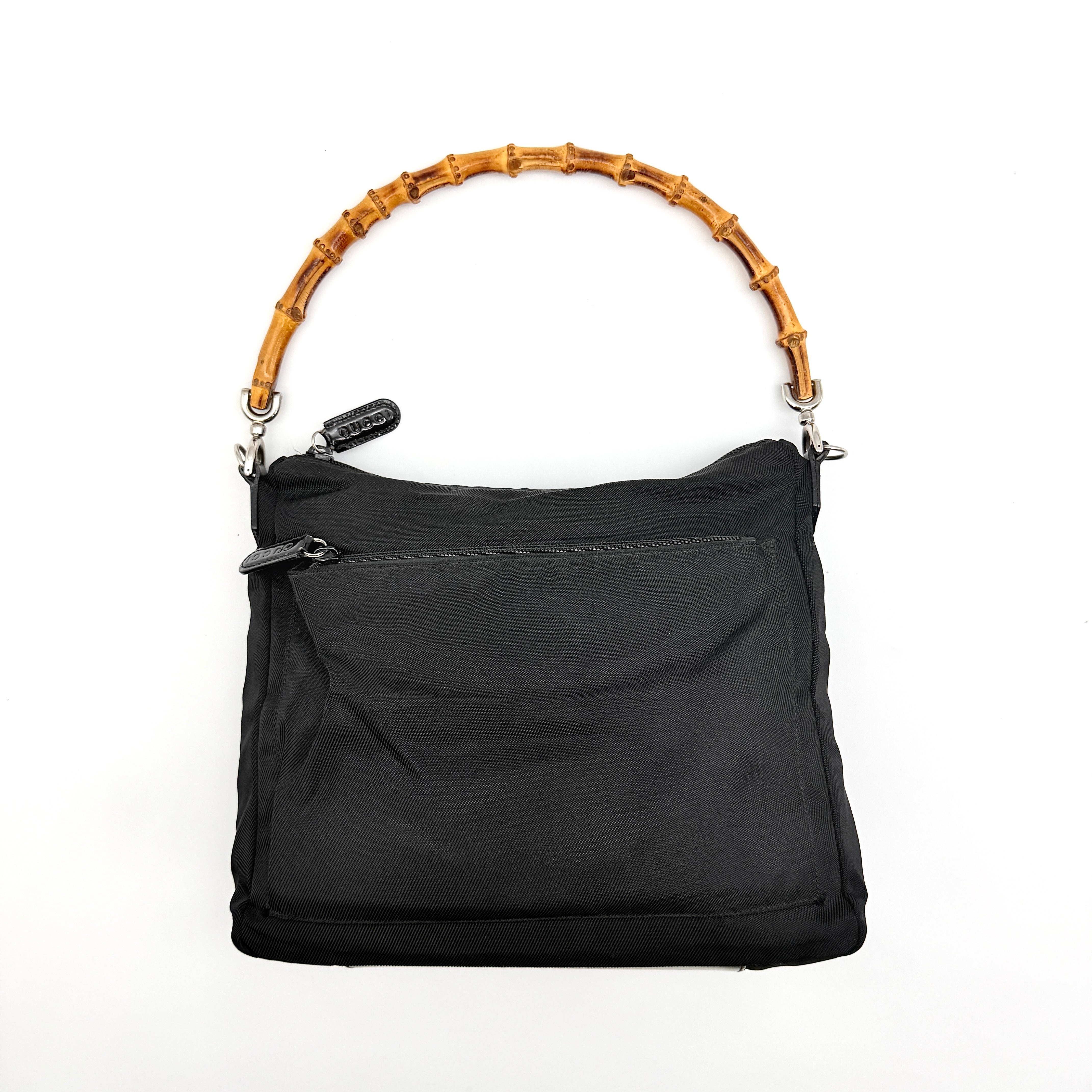 Gucci nylon shoulder bag in black with bamboo handle, shown against a white background.