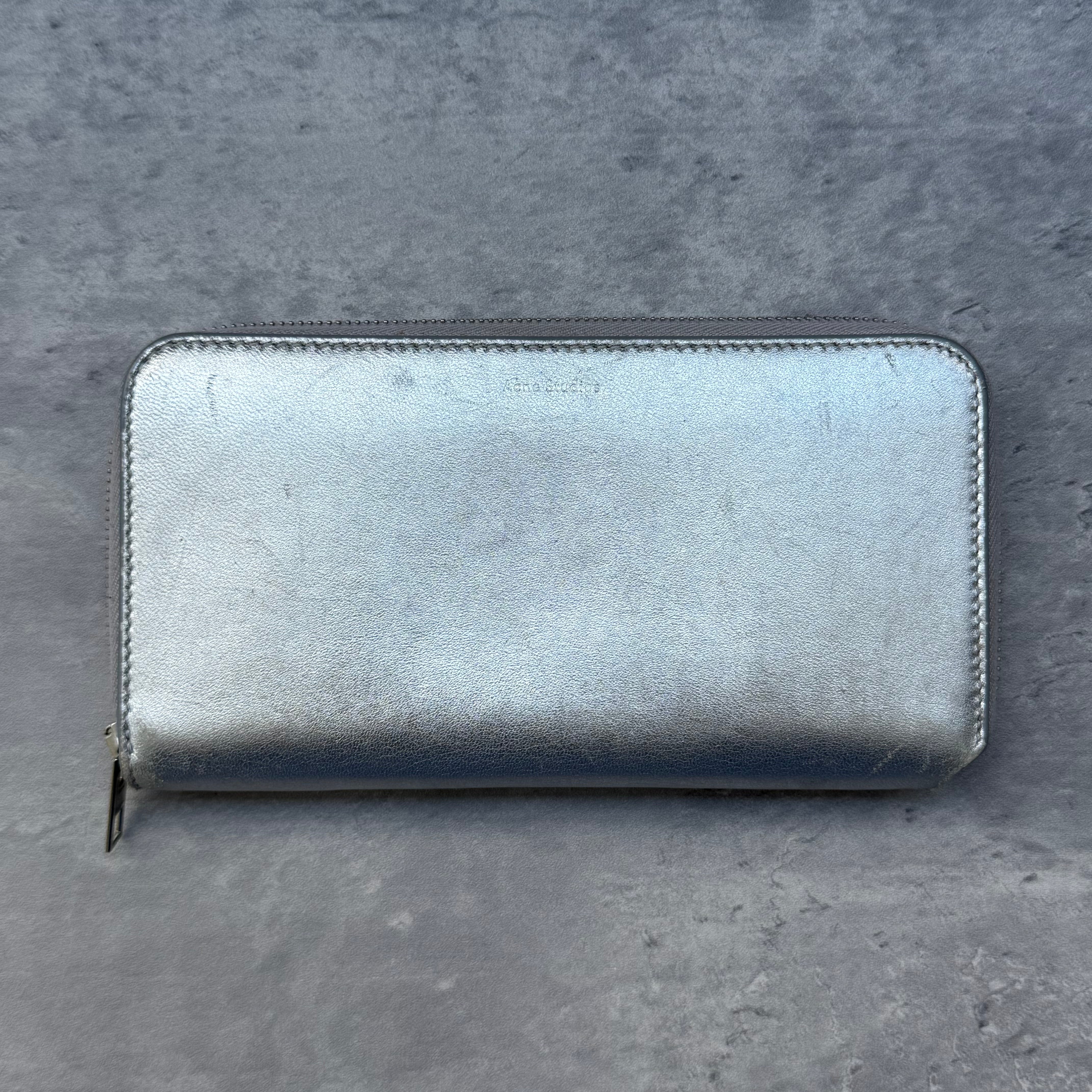 Acne Studios Metallic Silver Long Wallet in leather with zip-around closure and multiple compartments.
