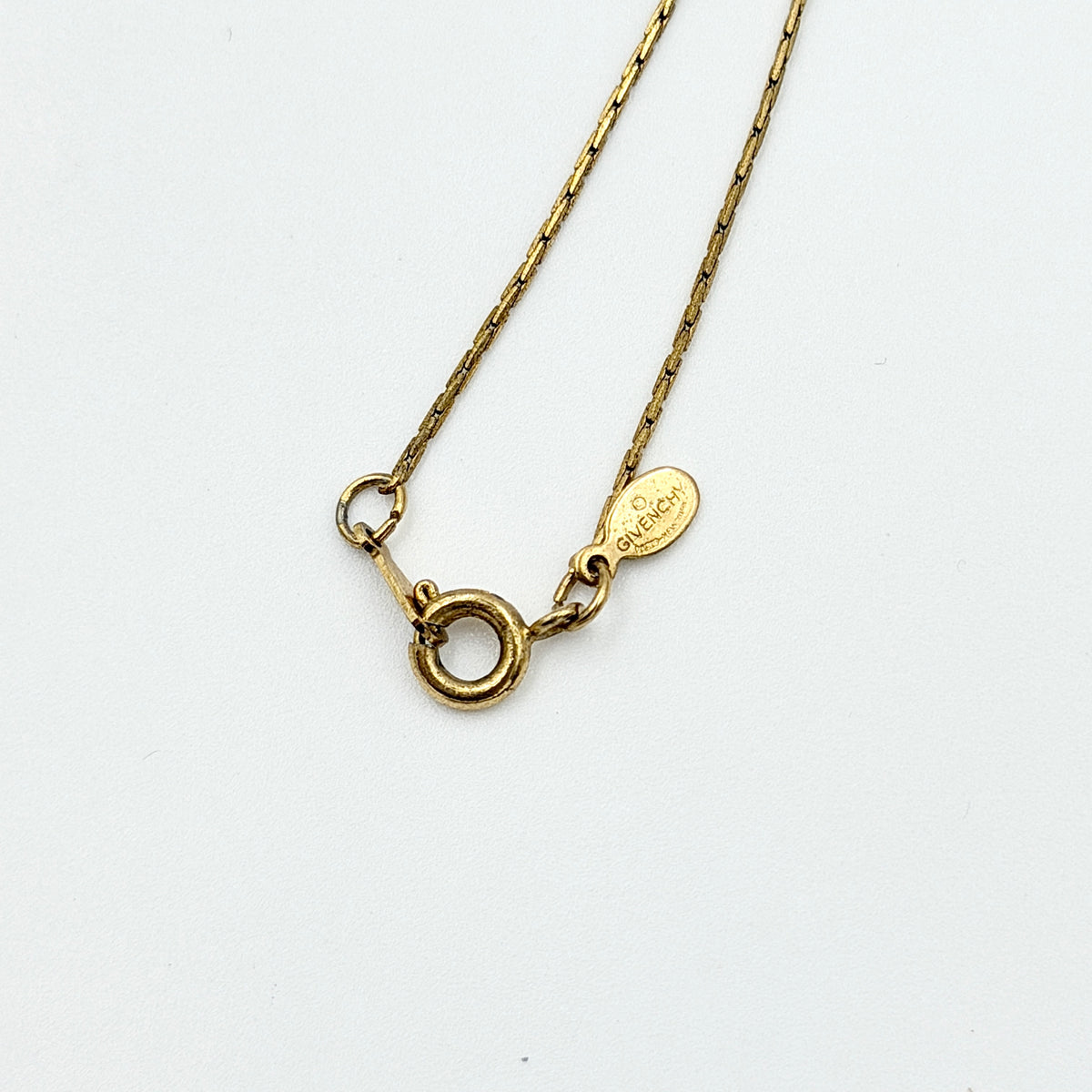 Givenchy 4G Logo Necklace in polished gold-tone metal with a geometric pendant on a fine chain.