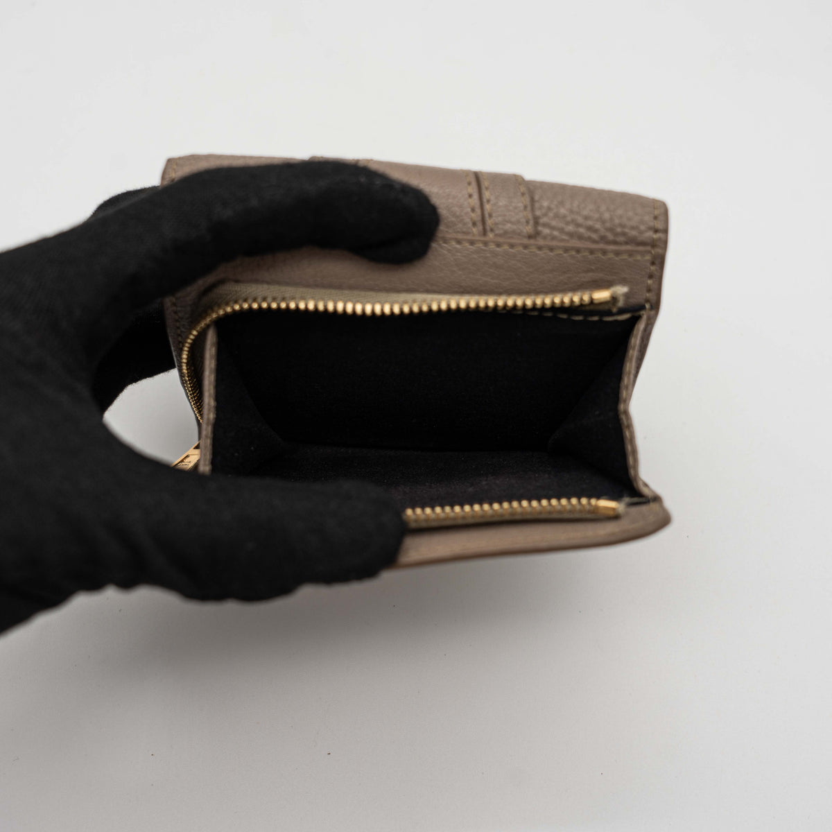 See by Chloe Hana tri-fold wallet in grey grained leather with gold-tone ring and charms, photographed closed on a white background.