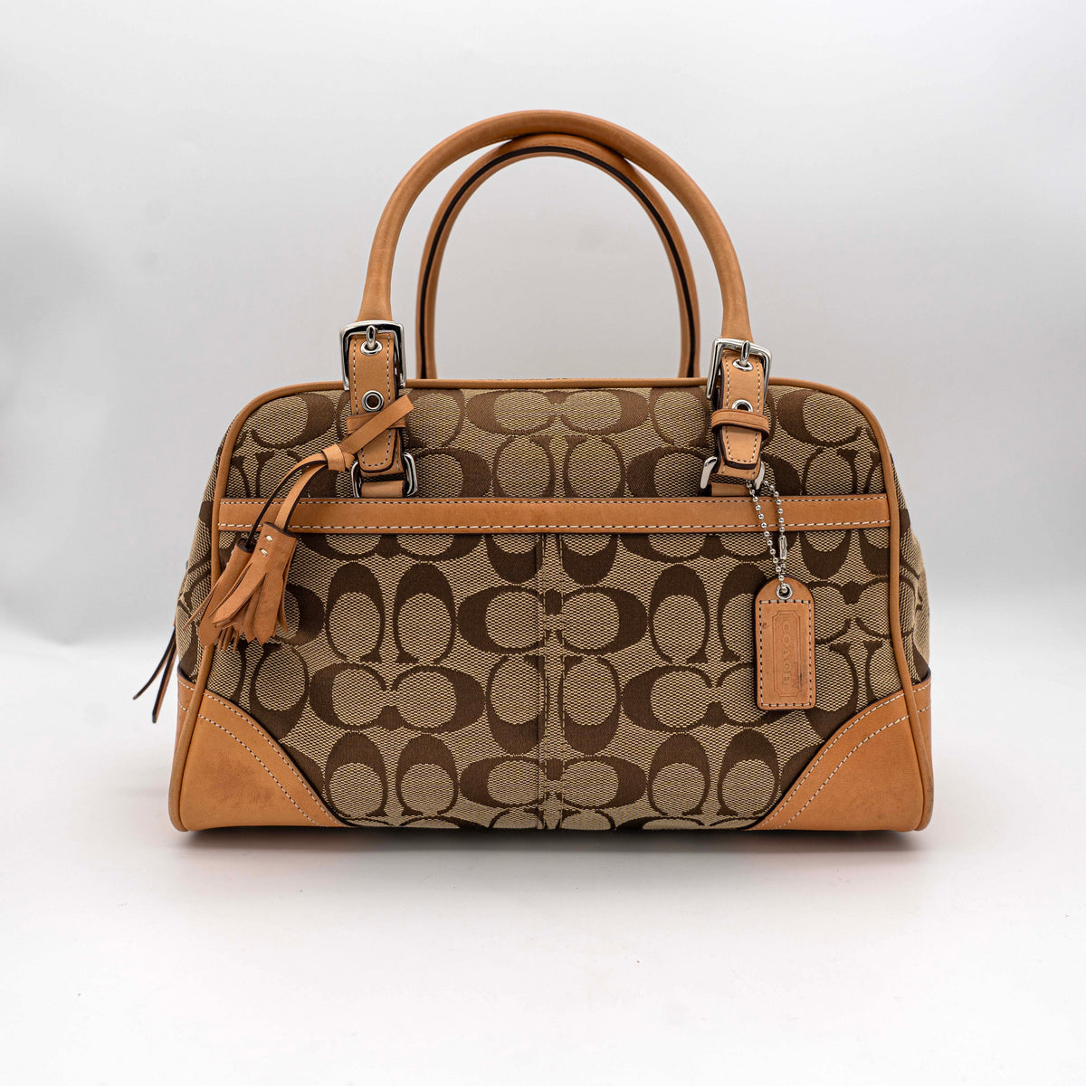 Coach Signature Hampton Satchel Boston Bag in beige and tan canvas with leather trim and silver hardware, styled on a clean background.