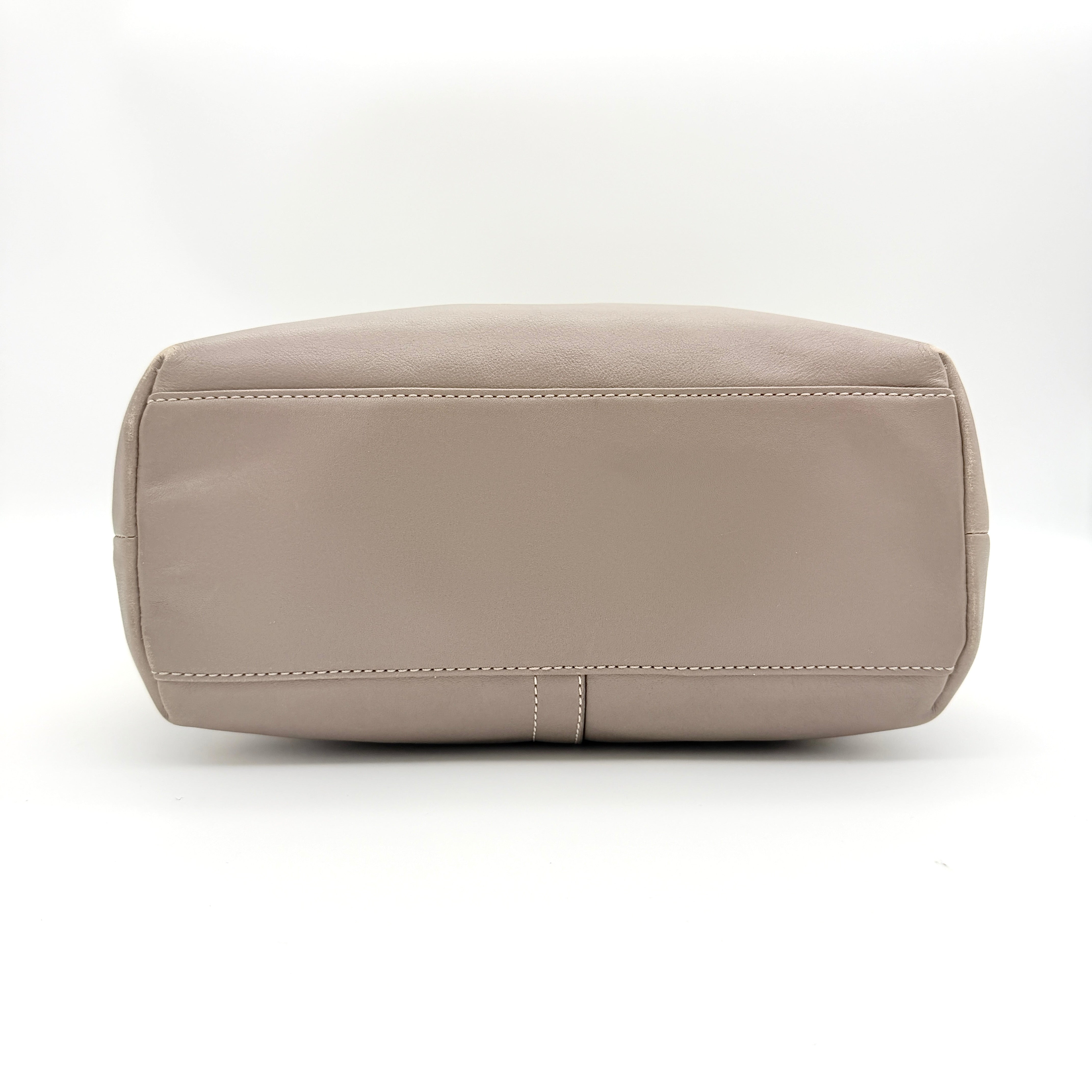Coach Hampton Weekend perforated cream and grey leather tote bag with tan handles and a silver Coach charm, displayed against a white background.