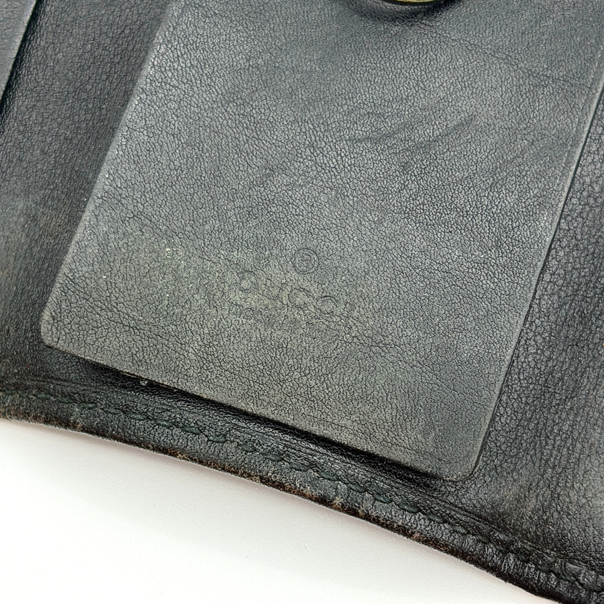 Gucci Guccissima GG Monogram black leather key case with silver-tone hardware, shown closed against a white background.