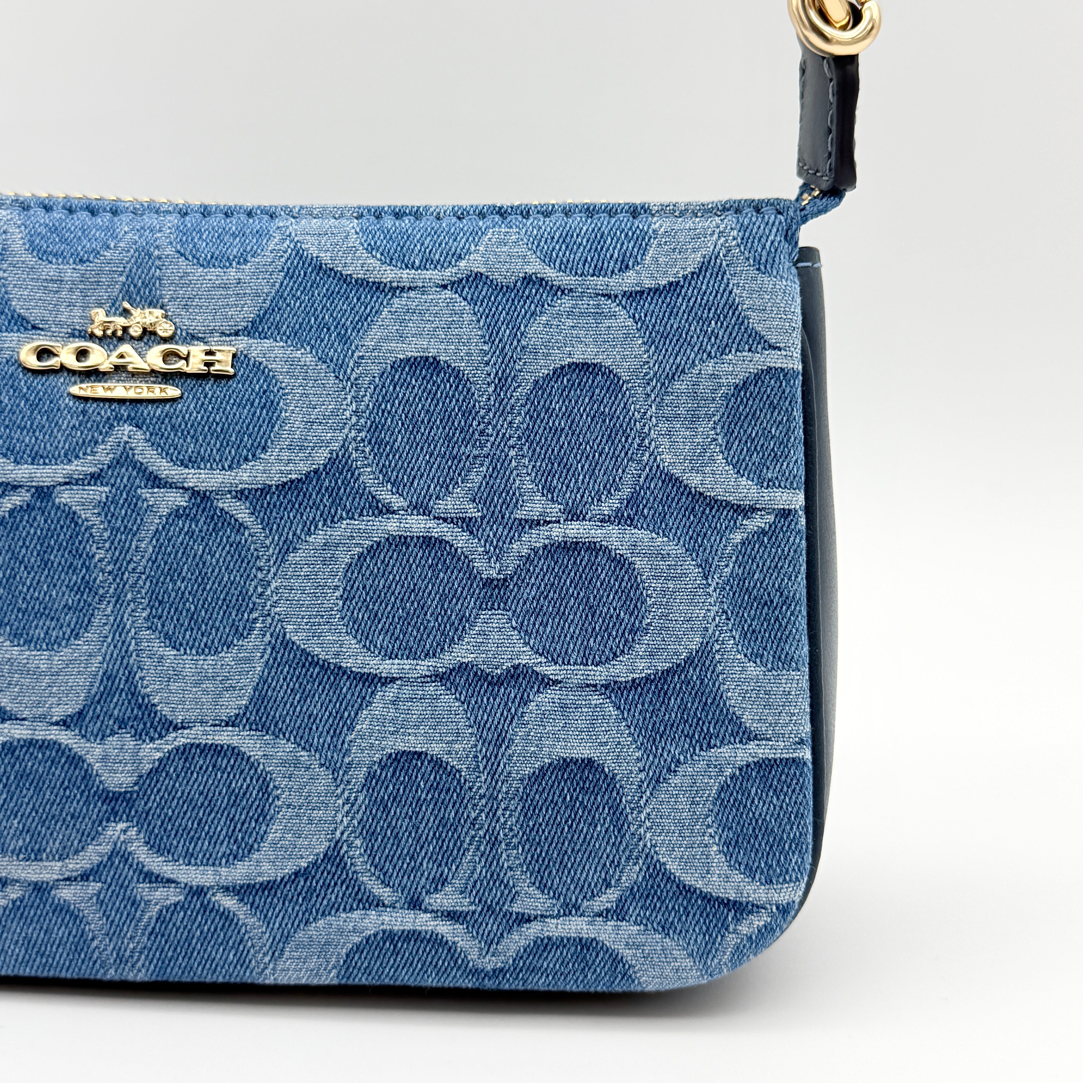 Coach Nolita 19 shoulder bag in blue denim jacquard with monogram print and gold hardware, shown with original packaging.