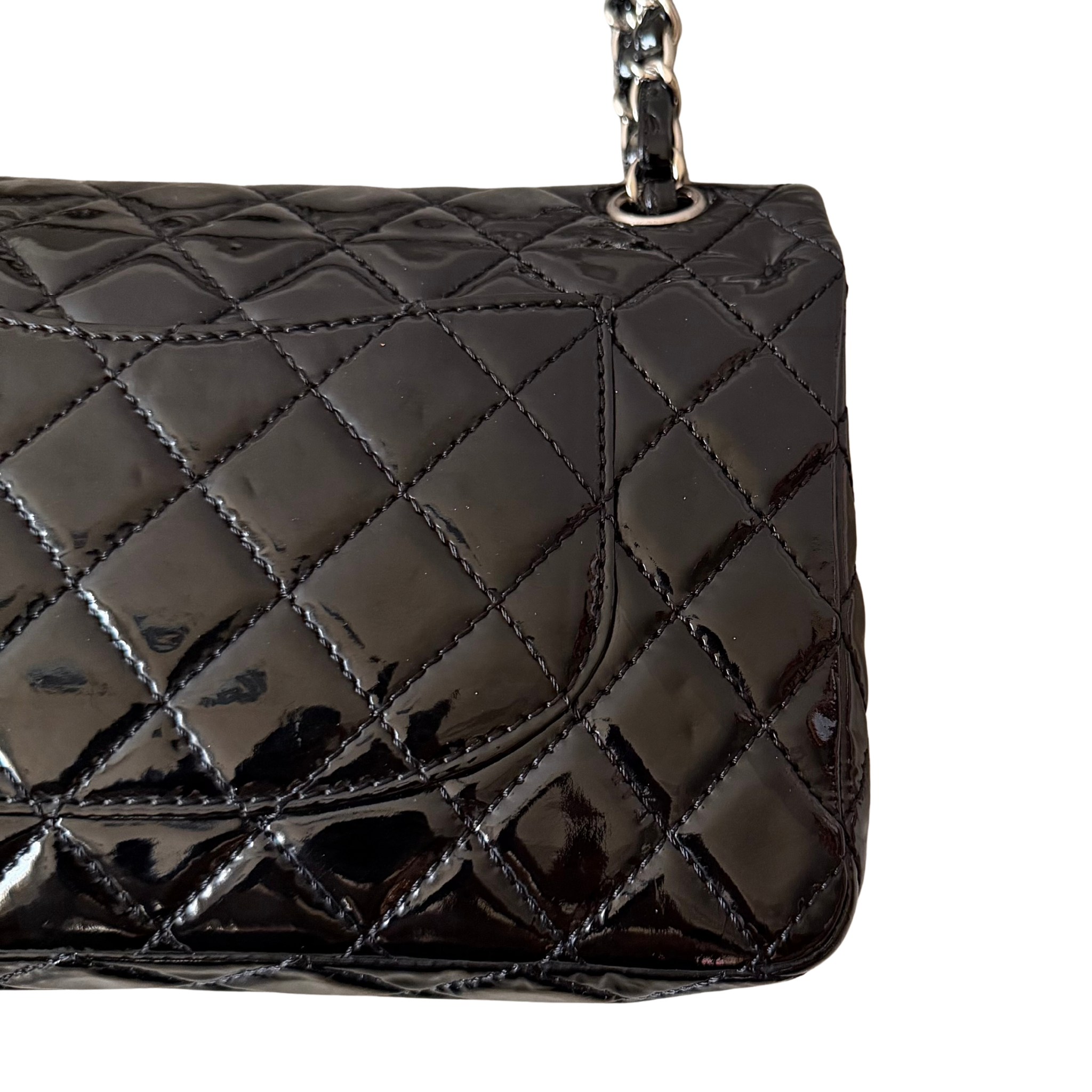 Chanel 25 Matelasse Double Flap bag in glossy black patent leather with silver-tone hardware and quilted finish.