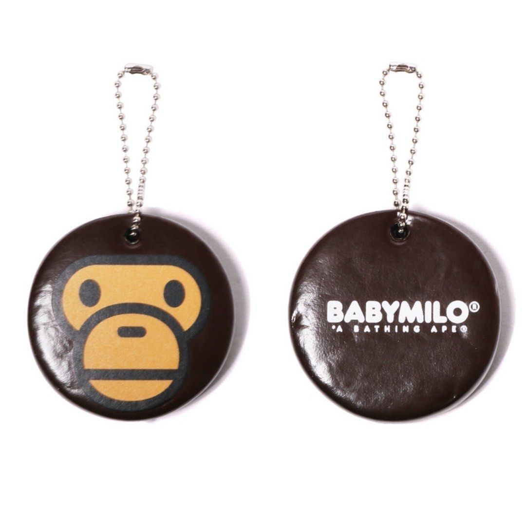 BAPE Baby Milo Keychain, round brown charm featuring Baby Milo face on one side and BABYMILO logo on the back with ball chain.