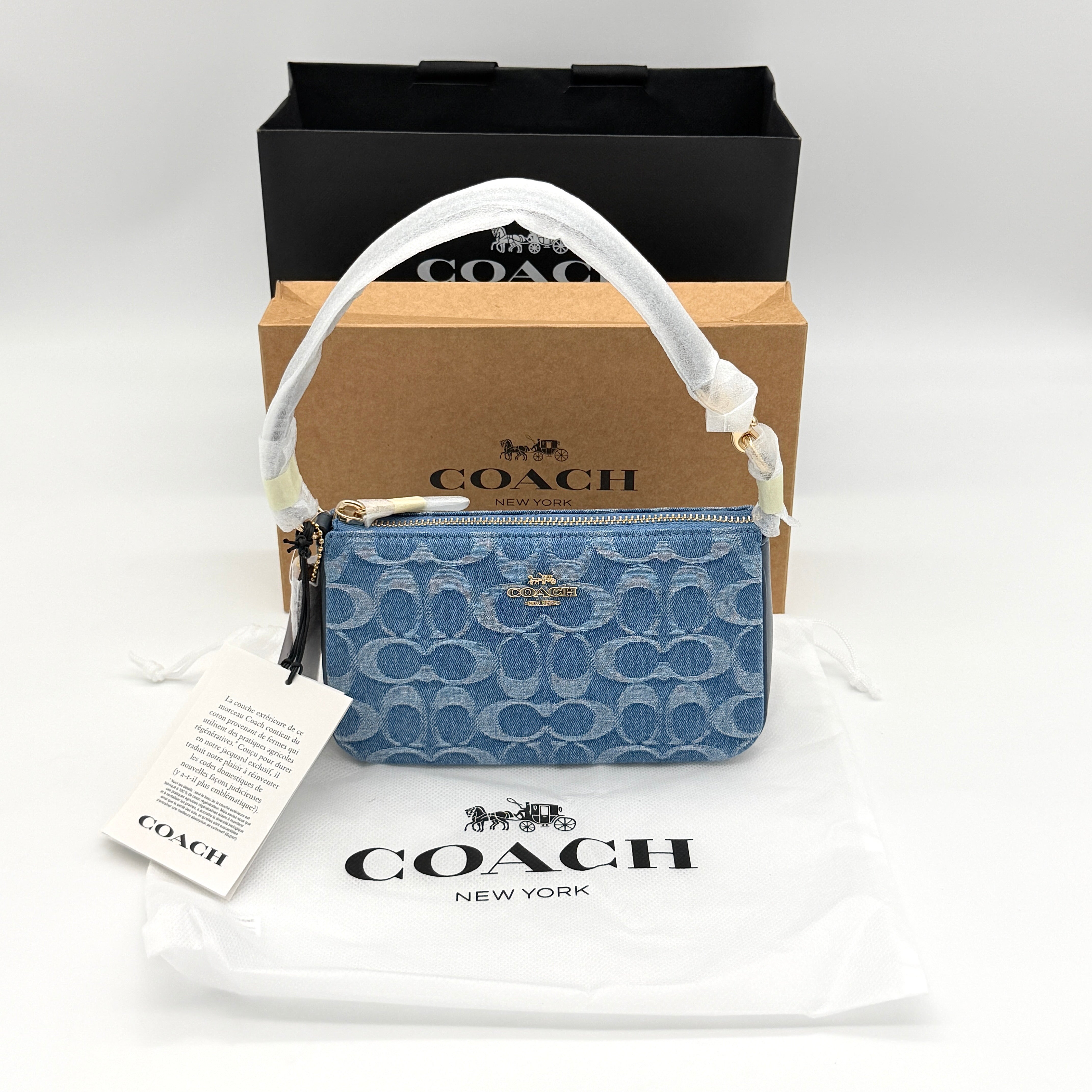 Coach Nolita 19 shoulder bag in blue denim jacquard with monogram print and gold hardware, shown with original packaging.