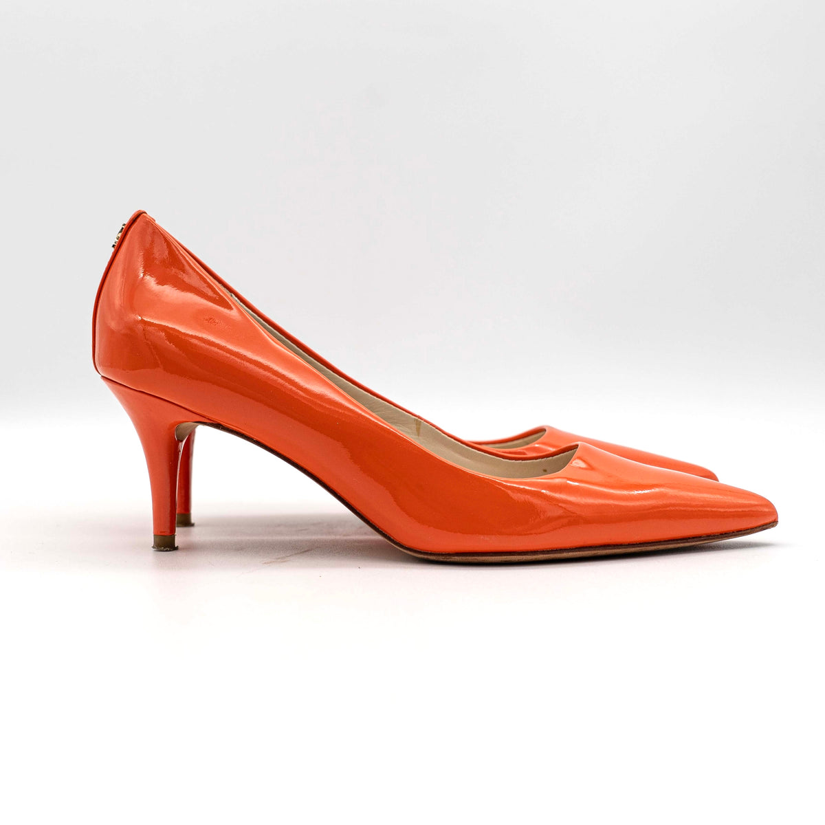 Pair of Coach orange patent leather pointed-toe heels with gold logo detail, size EU 35.5.