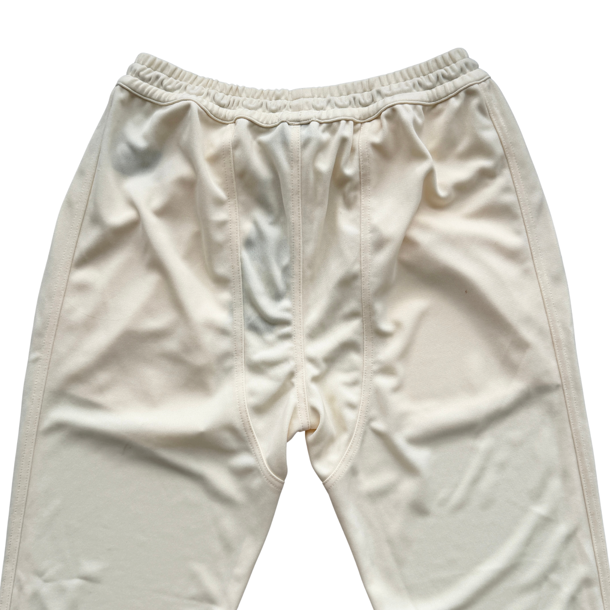 Rhude lounge track pants in cream with yellow drawstrings, displayed flat against a white background.