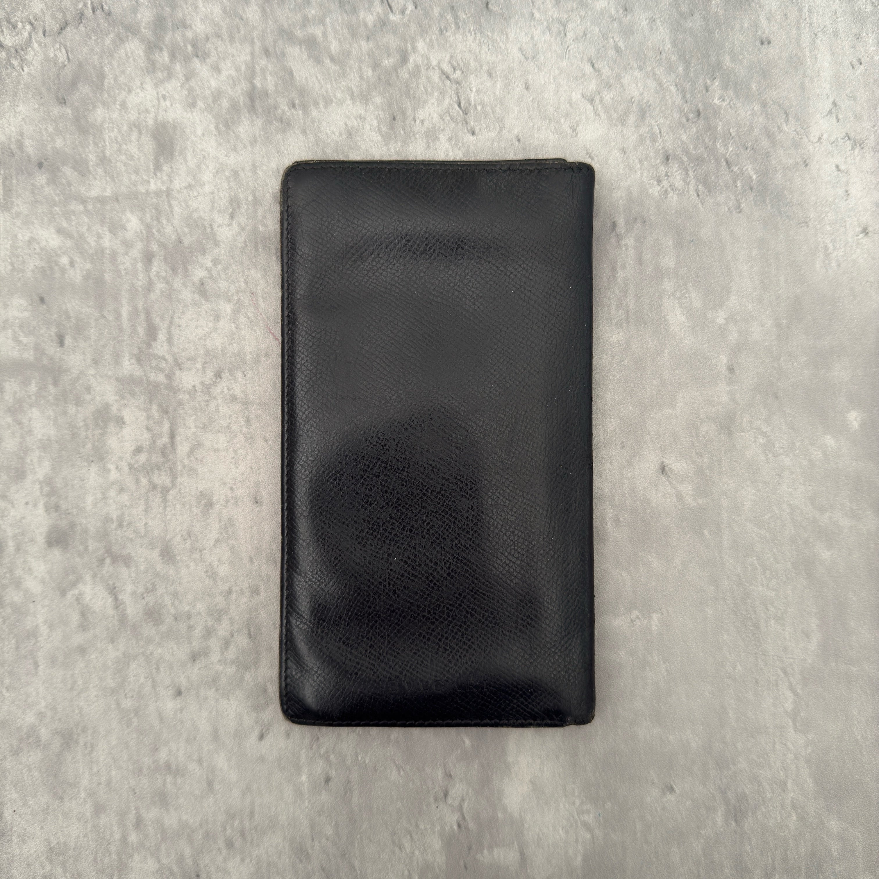 Bvlgari Bi-Fold Leather Black Long Wallet, crafted from textured black leather with multiple card slots and bill compartments for organization.