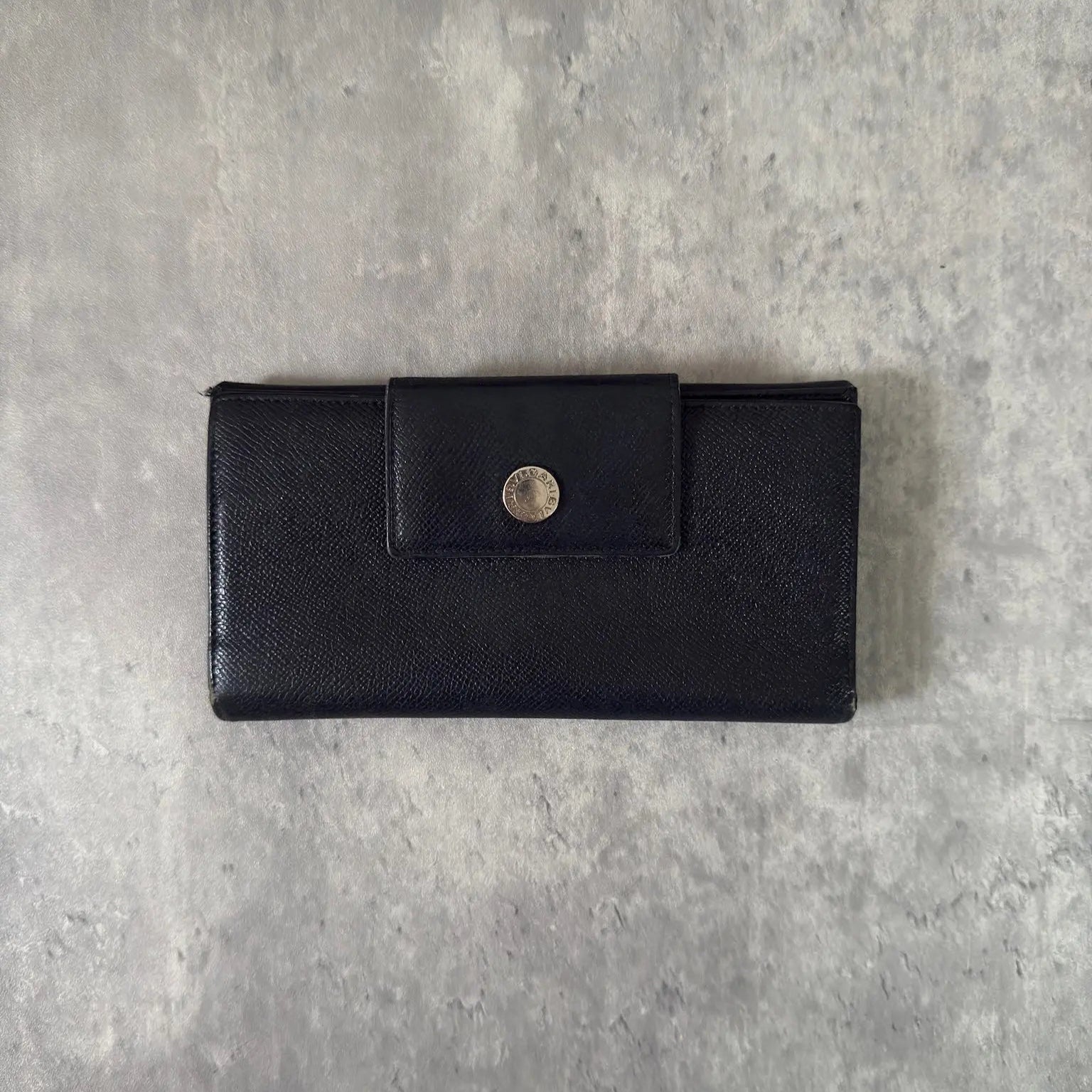Bvlgari Classico Long Wallet in black leather, featuring a silver-tone logo clasp, multiple card slots, and a spacious bill compartment, showcasing understated luxury and sophistication.