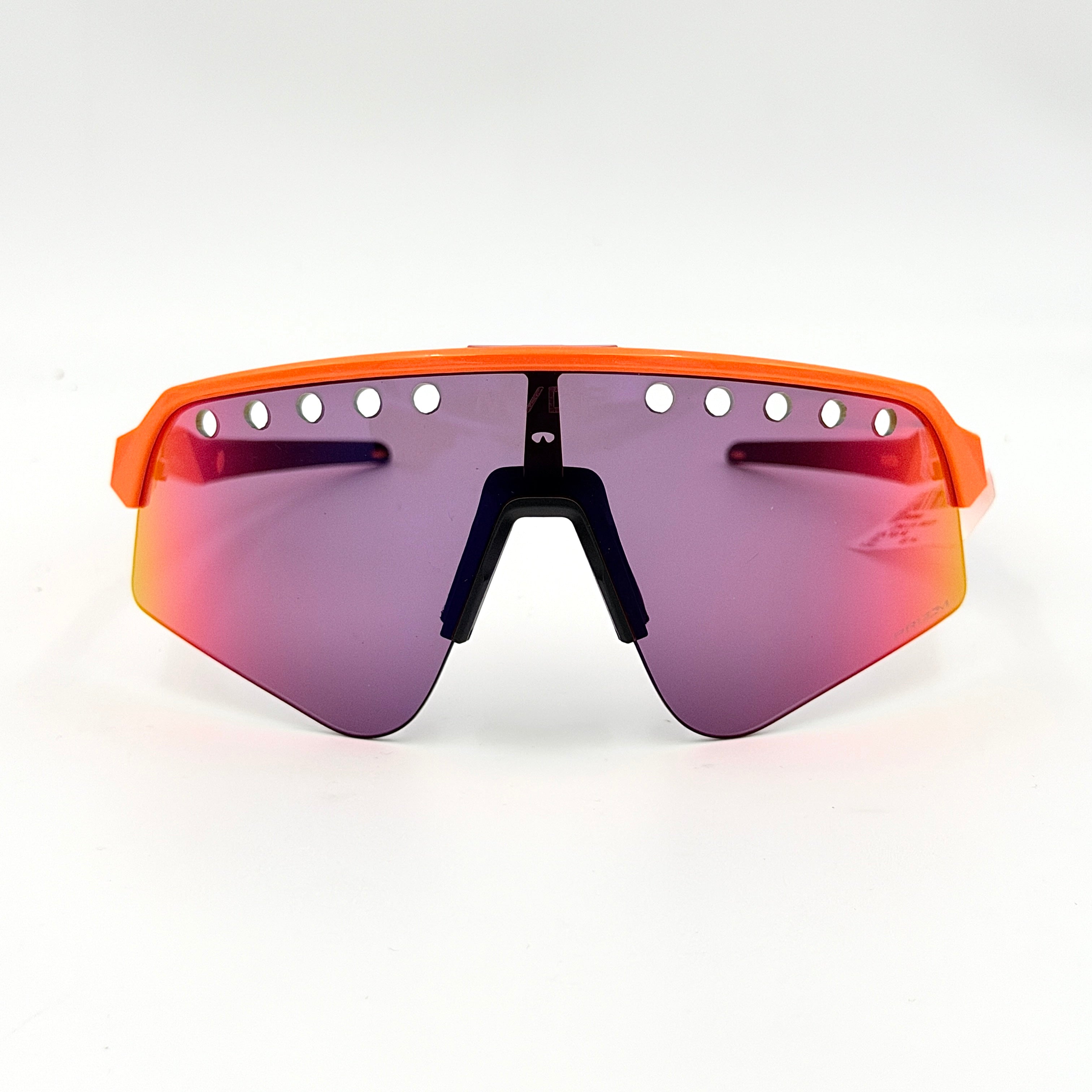 Oakley Sutro Lite Sweep MVDP Prizm Road sunglasses in orange sparkle with a shield lens and original pouch, photographed in bright studio lighting.