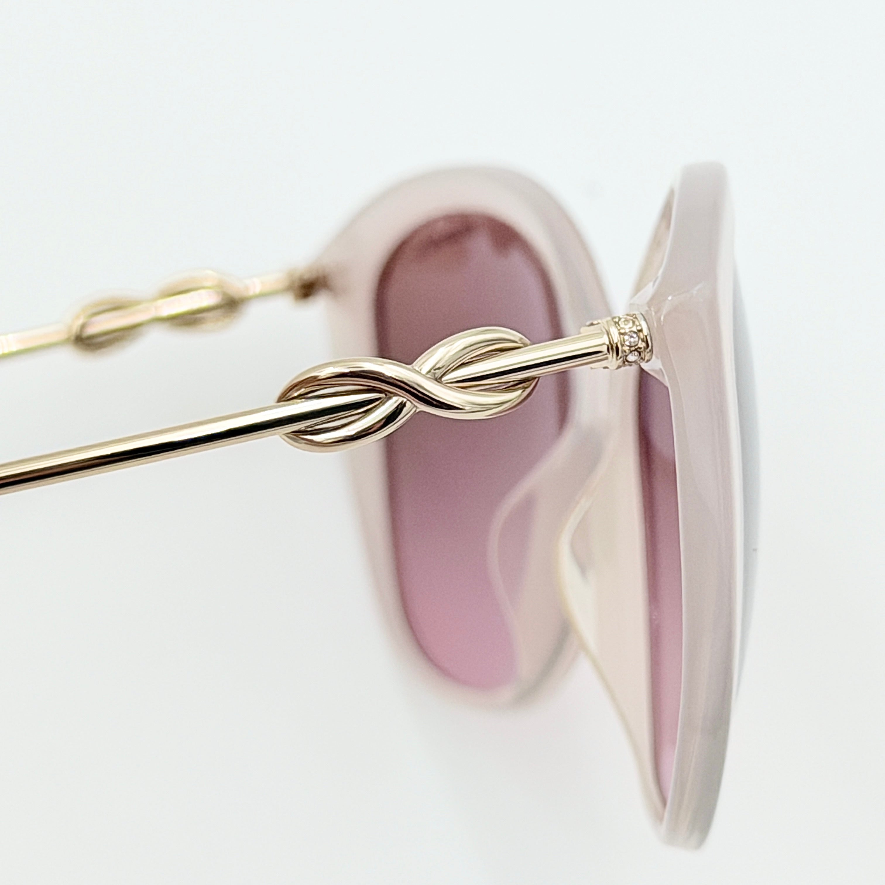 Tiffany & Co. TF4144 sunglasses in pink with gold-tone knot detail arms, shown with signature blue case.
