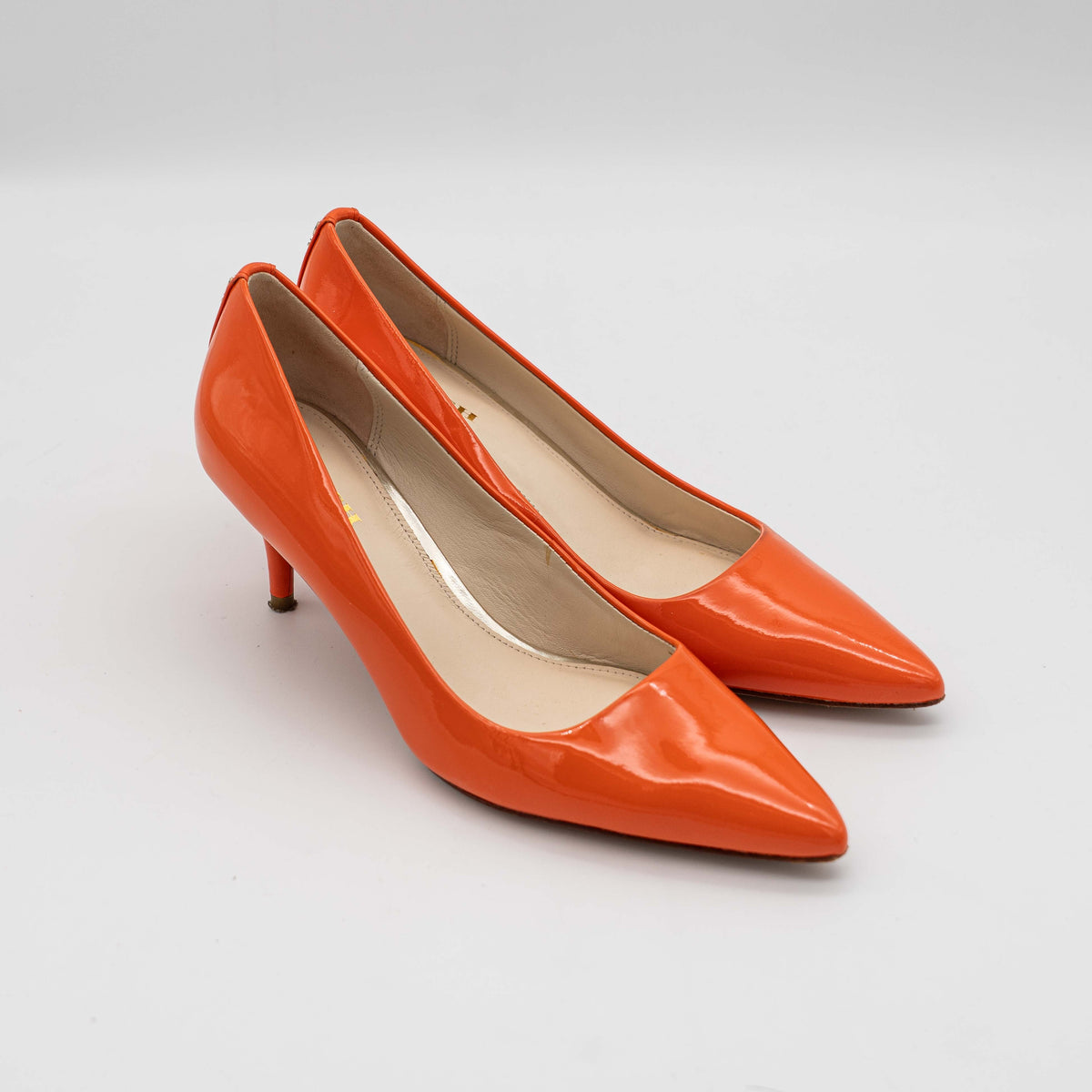 Pair of Coach orange patent leather pointed-toe heels with gold logo detail, size EU 35.5.