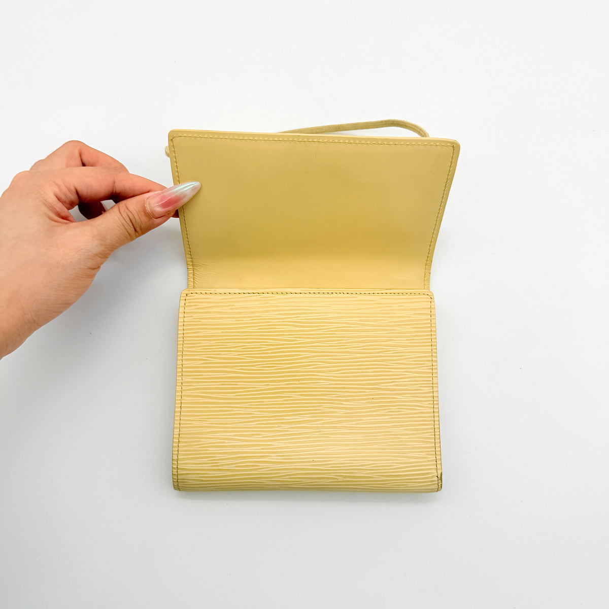 Louis Vuitton Epi Portefeuille Élastique Trifold Wallet in Vanilla Cream with dust bag, presented against a clean white background.
