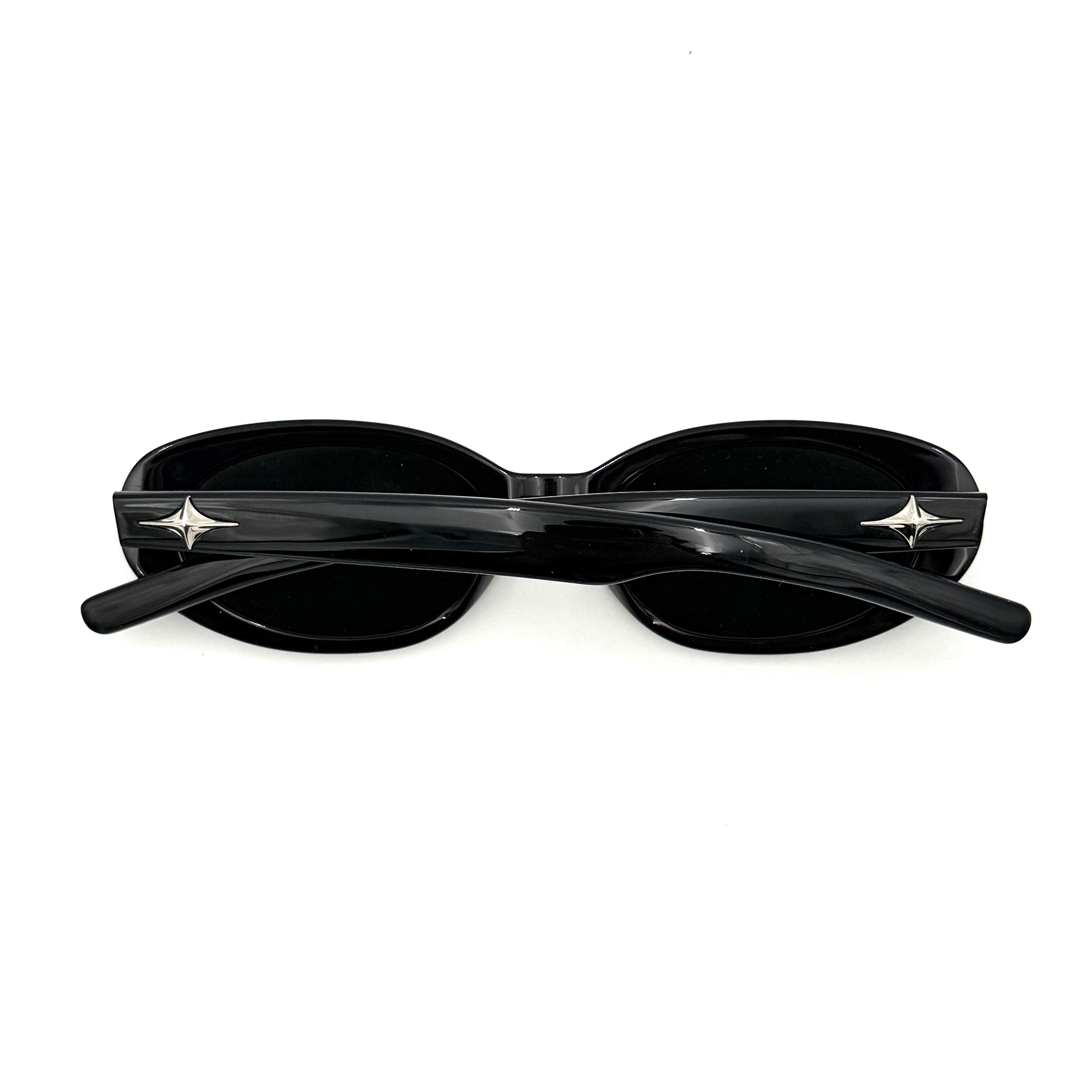 Gentle Monster Bandoneon.S sunglasses in black acetate with dark oval lenses and silver star accents shown from the side.