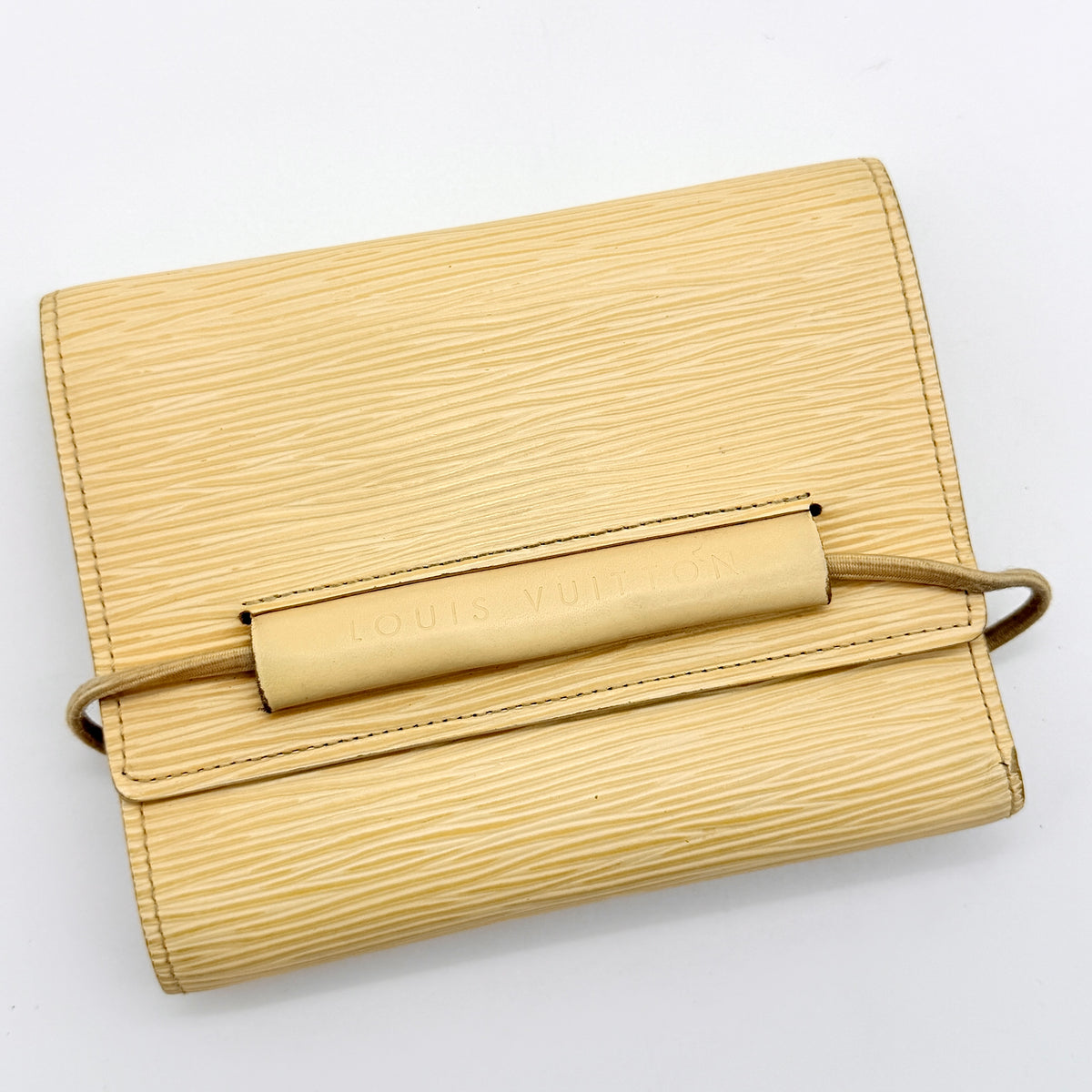 Louis Vuitton Epi Portefeuille Élastique Trifold Wallet in Vanilla Cream with dust bag, presented against a clean white background.