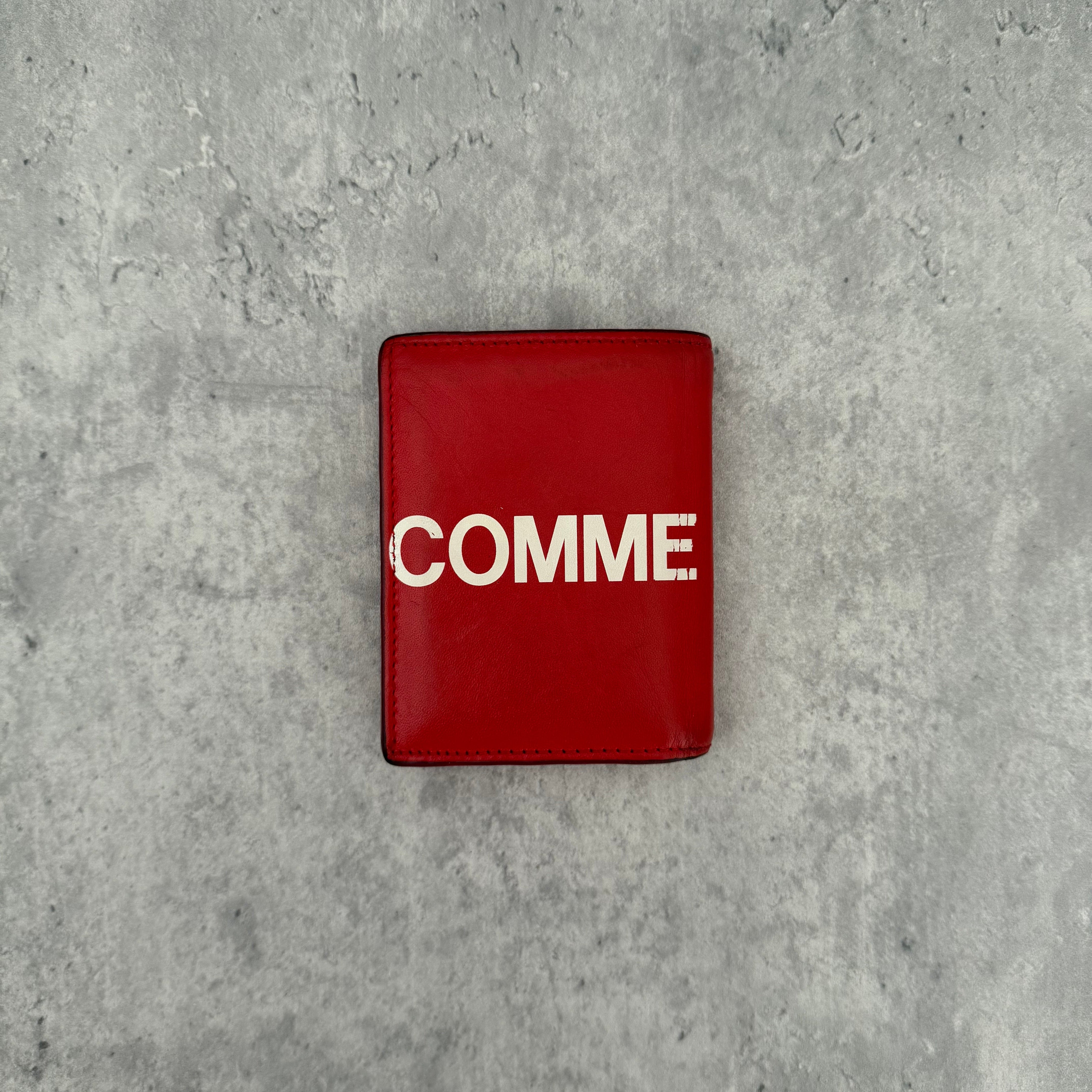 COMME des GARÇONS Huge Logo Red Leather Wallet with oversized white print and multiple card slots in a bi-fold design.