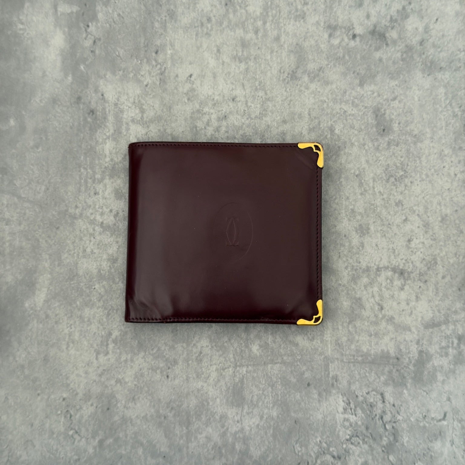 Cartier burgundy patent leather cardholder with multiple card slots, showcasing a luxurious and glossy finish, ideal for elegant organization.