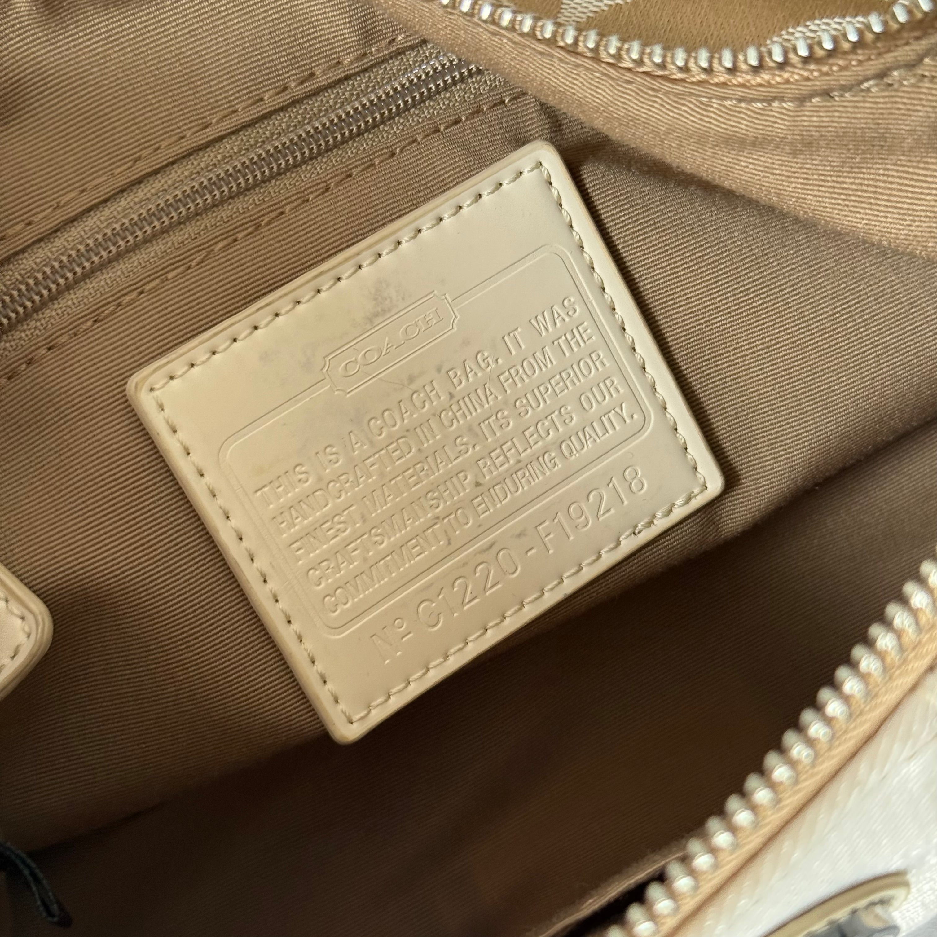 Coach 2-Way Signature Stripe Shoulder Bag in Beige and White with detachable strap, zip closure, and central white leather stripe with metal Coach emblem