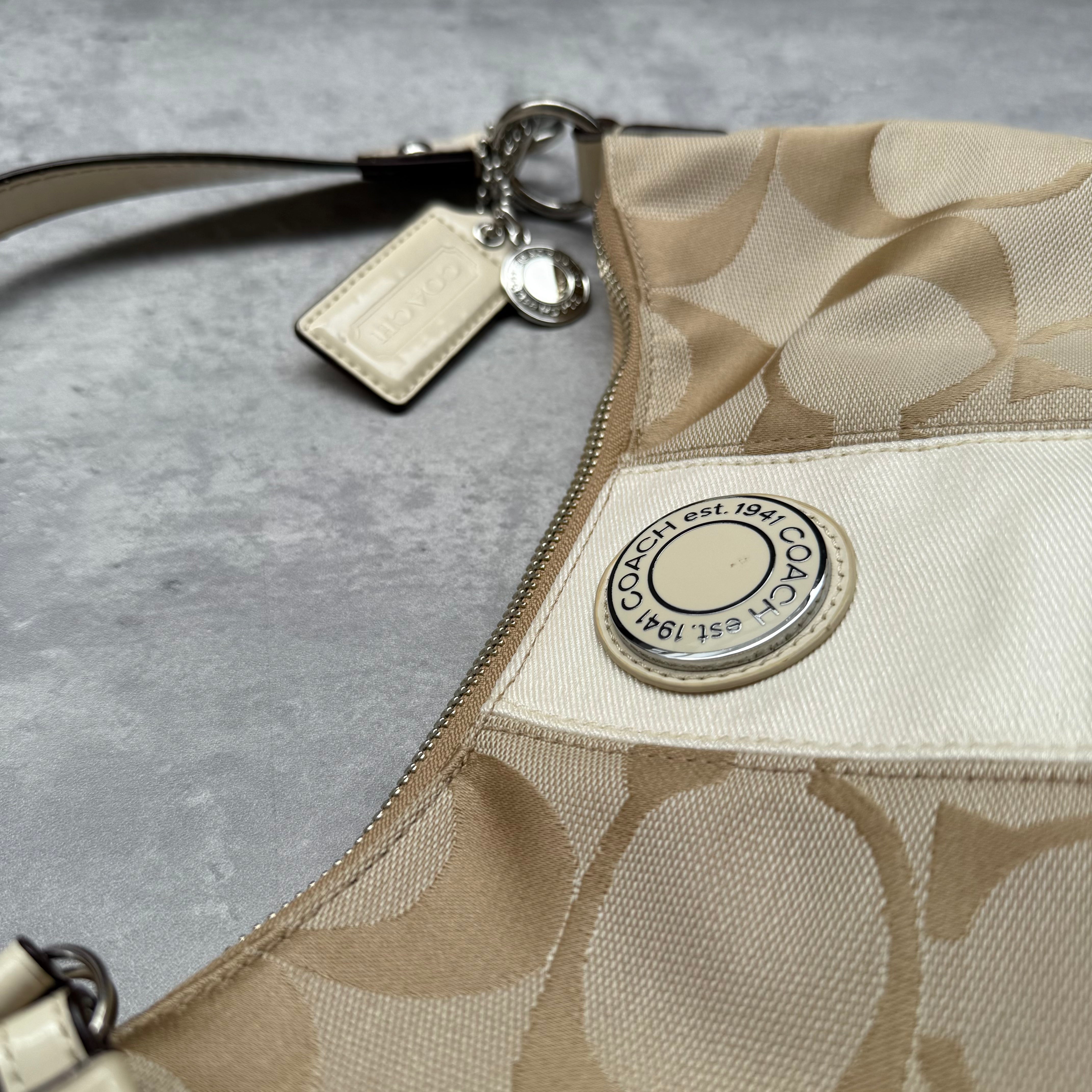Coach 2-Way Signature Stripe Shoulder Bag in Beige and White with detachable strap, zip closure, and central white leather stripe with metal Coach emblem