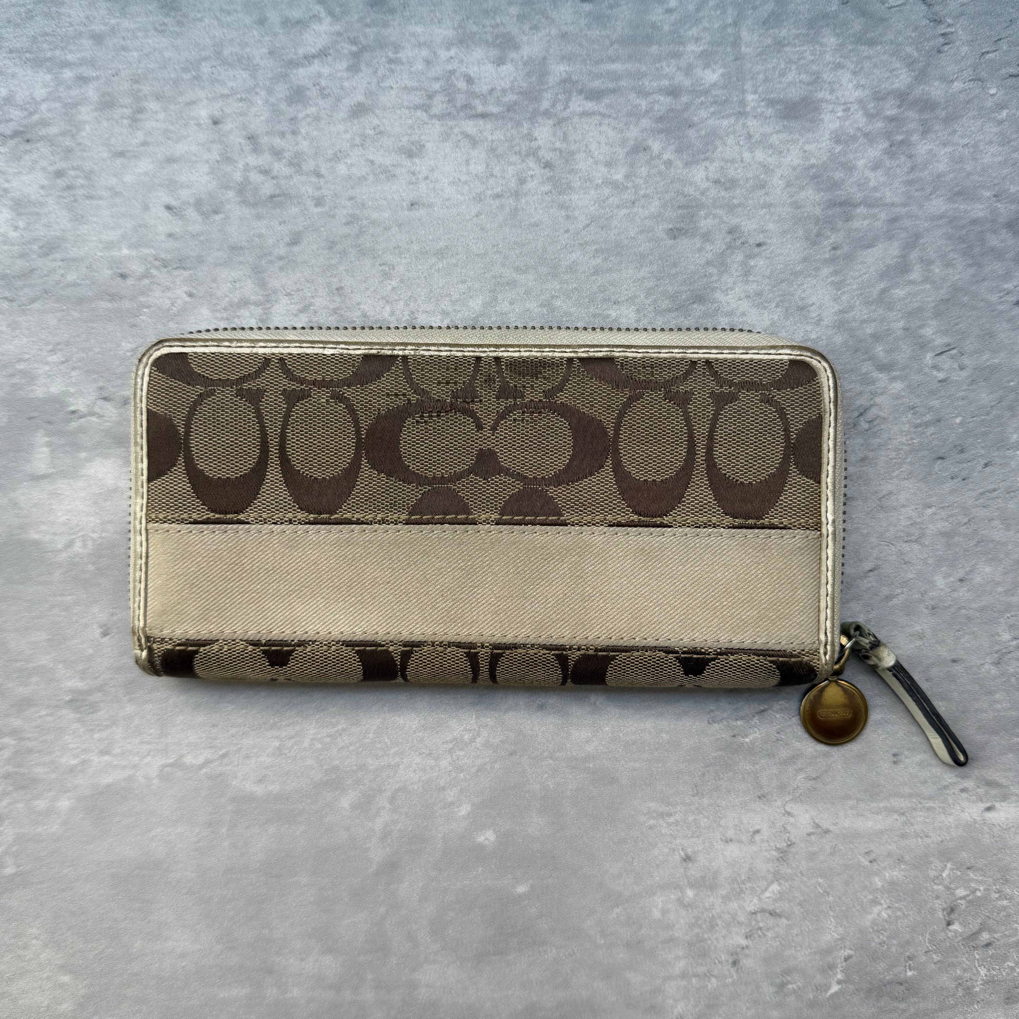 Coach Accordion Canvas Wallet in cream and tan signature jacquard with zip-around closure and colorful interior.