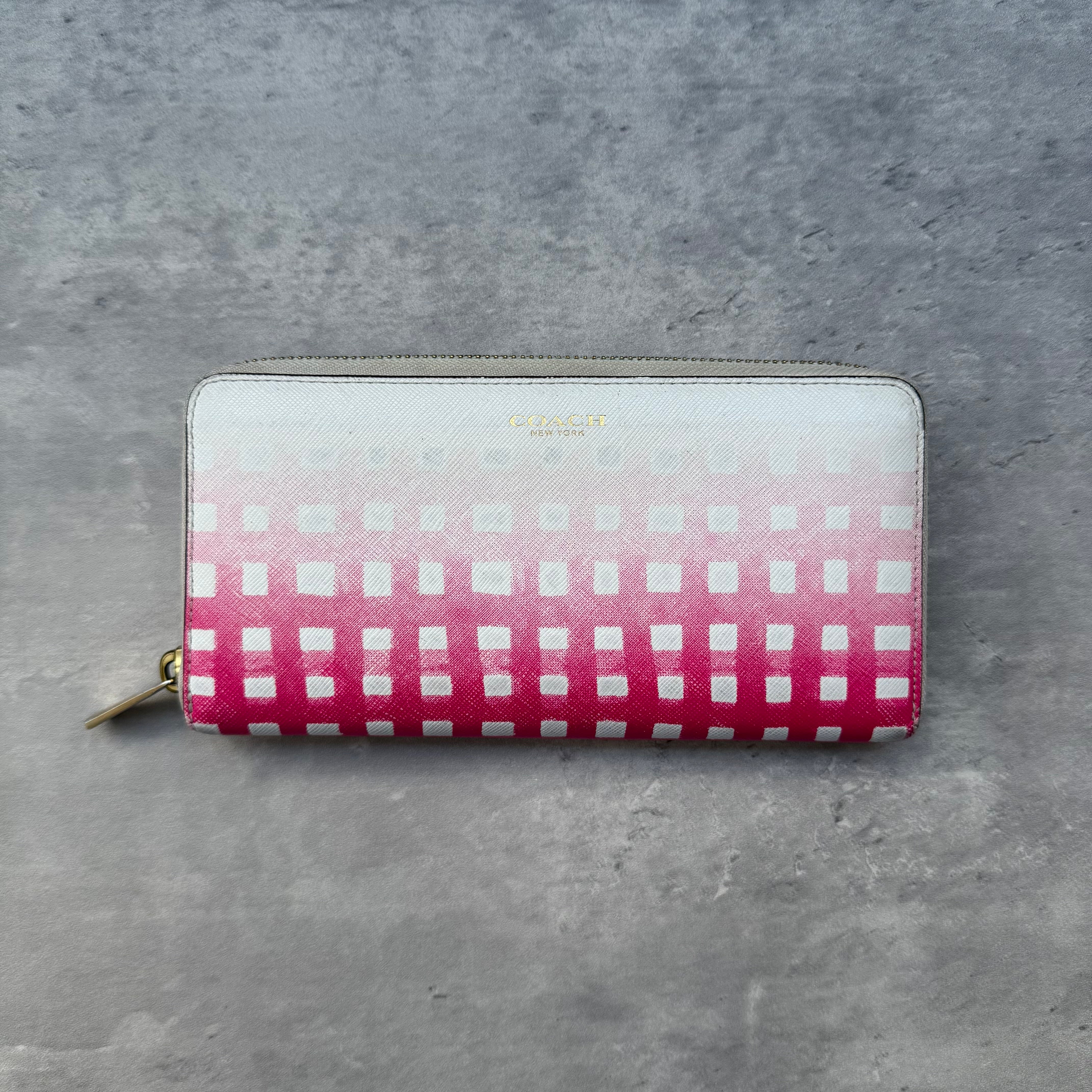Coach Accordion Zip Wallet in pink and white gradient dot print with zip-around closure and multiple compartments.