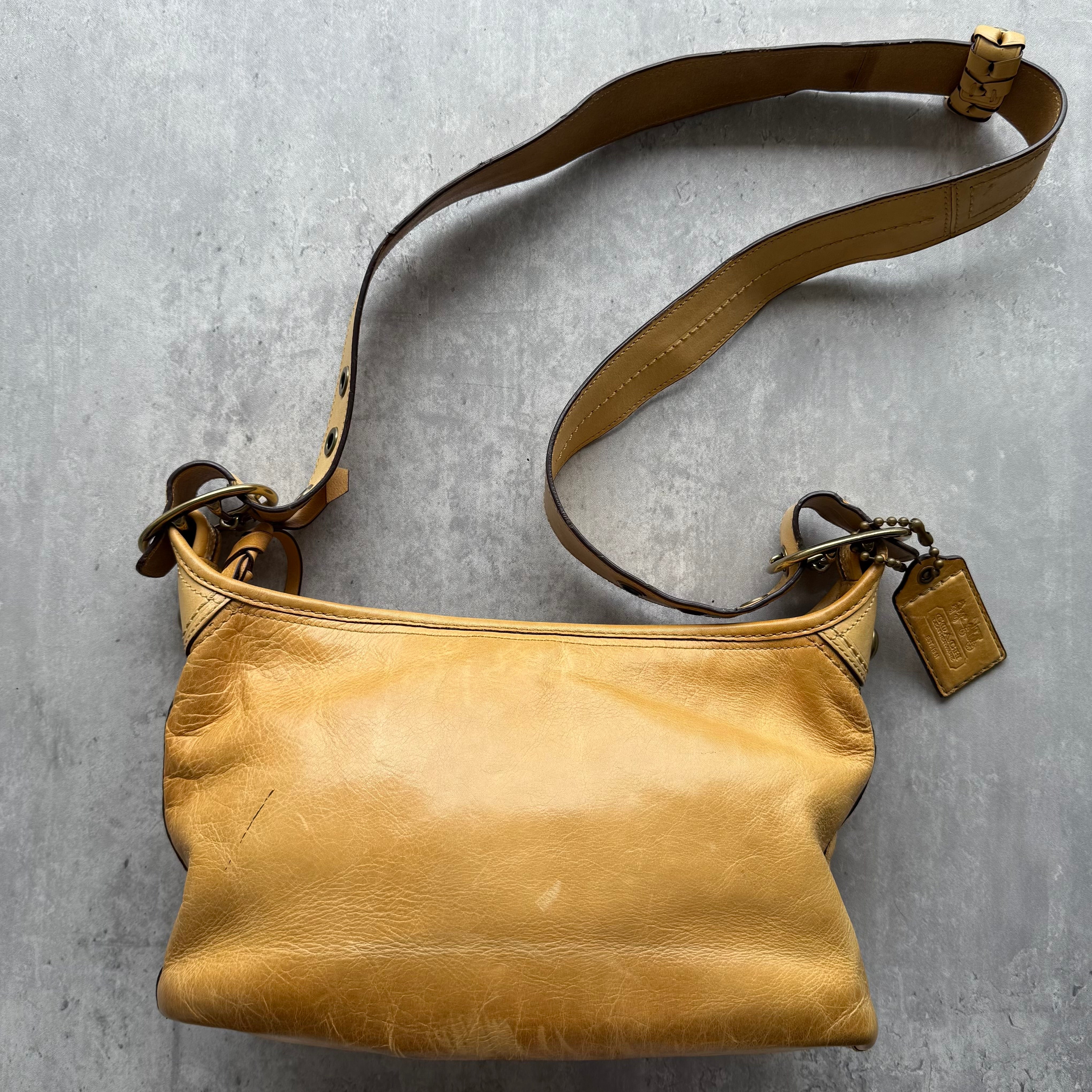 Coach Bleeker Crossbody Shoulder Bag in tan leather with plaid lining and adjustable strap.