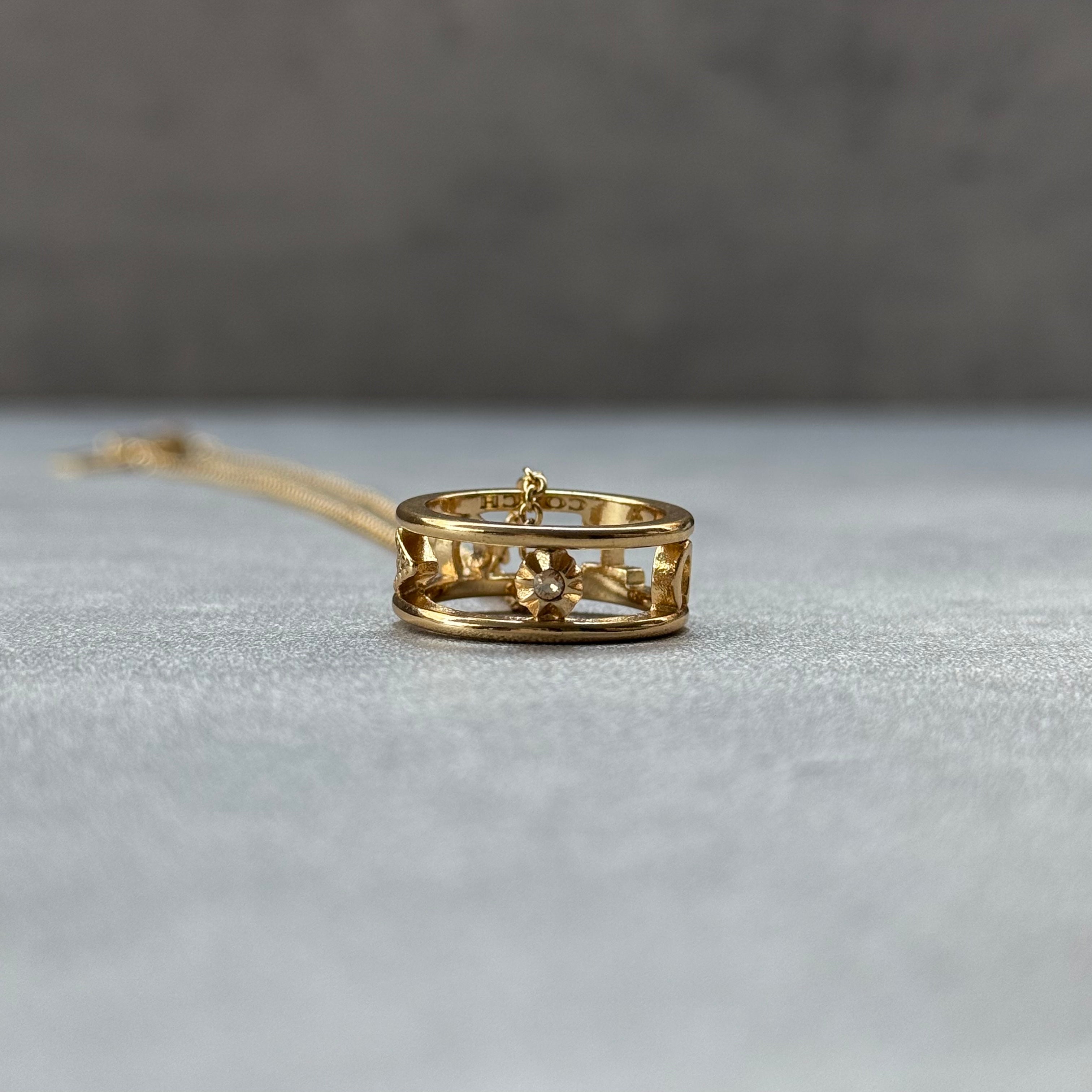 Coach C Open Ring Pendant Necklace Gold, featuring gold-tone chain with signature C motif ring pendant and crystal detail.