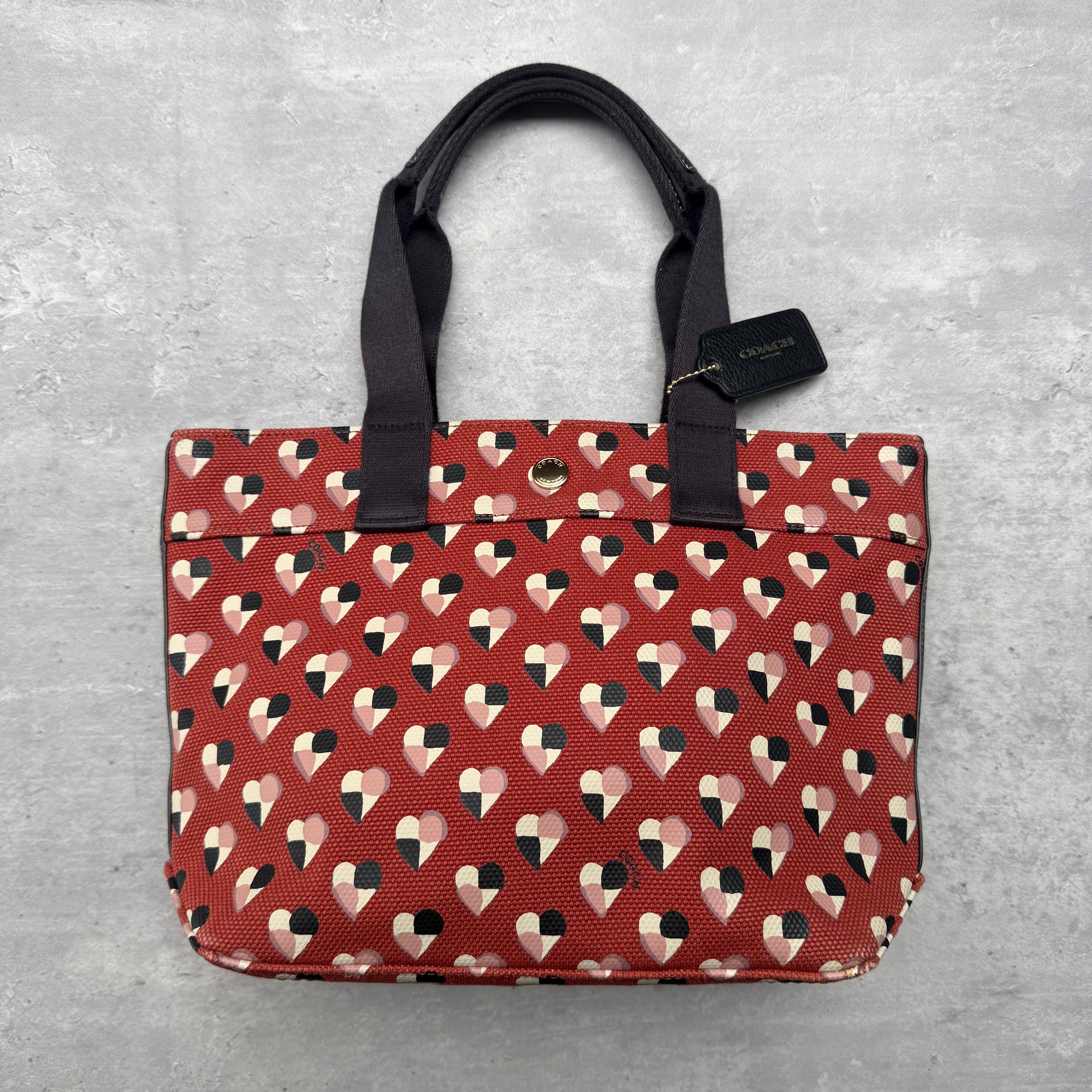 Coach Checkered Heart Print Tote Bag in red coated canvas with multicolor heart pattern and silver-tone hardware.