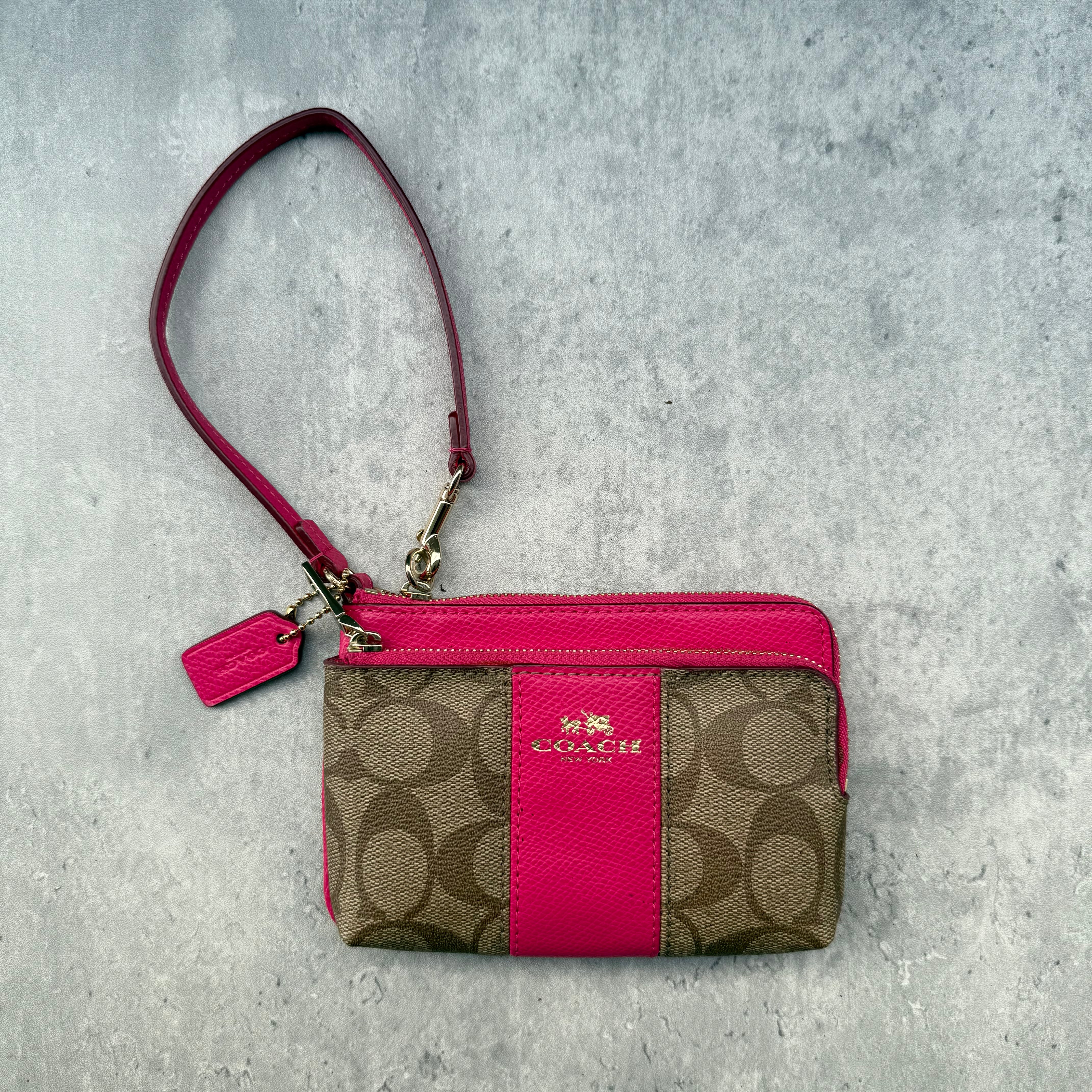 Coach Double Corner Zip Wristlet Pink/Beige, featuring signature coated canvas with pink leather trim and two zip compartments.