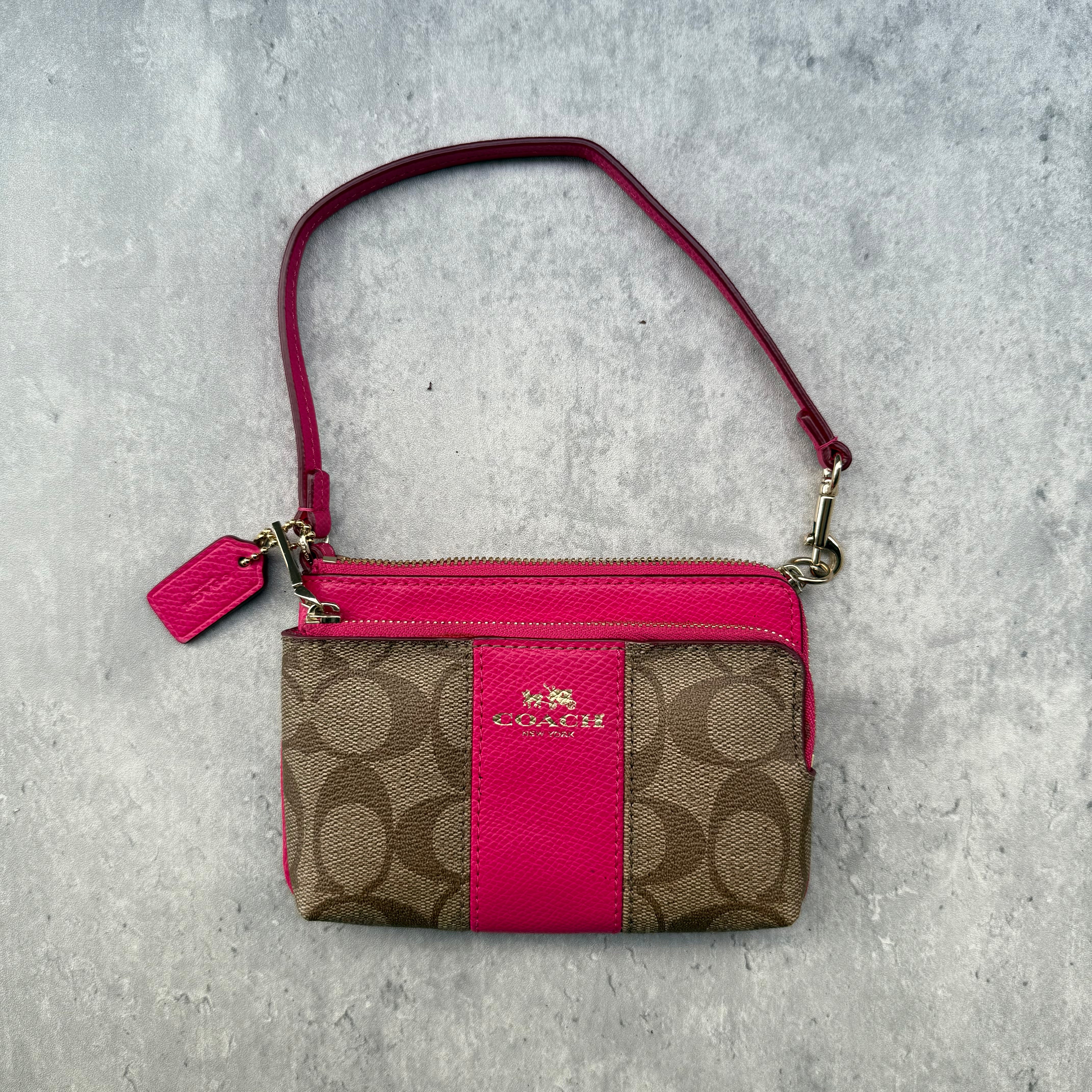Coach Double Corner Zip Wristlet Pink/Beige, featuring signature coated canvas with pink leather trim and two zip compartments.