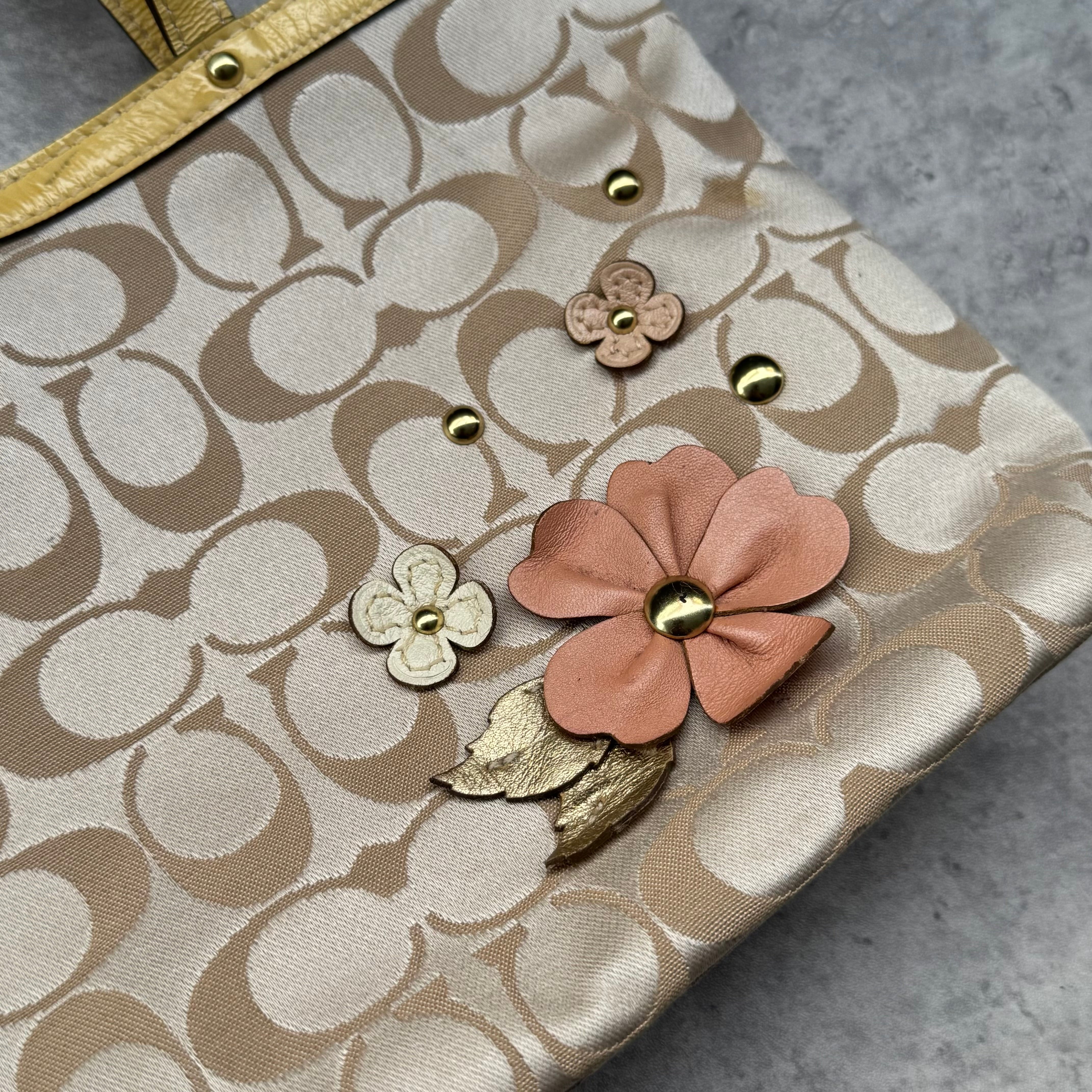 Coach Floral Applique Tote Bag in beige signature canvas with yellow leather trim and pastel leather flower details.