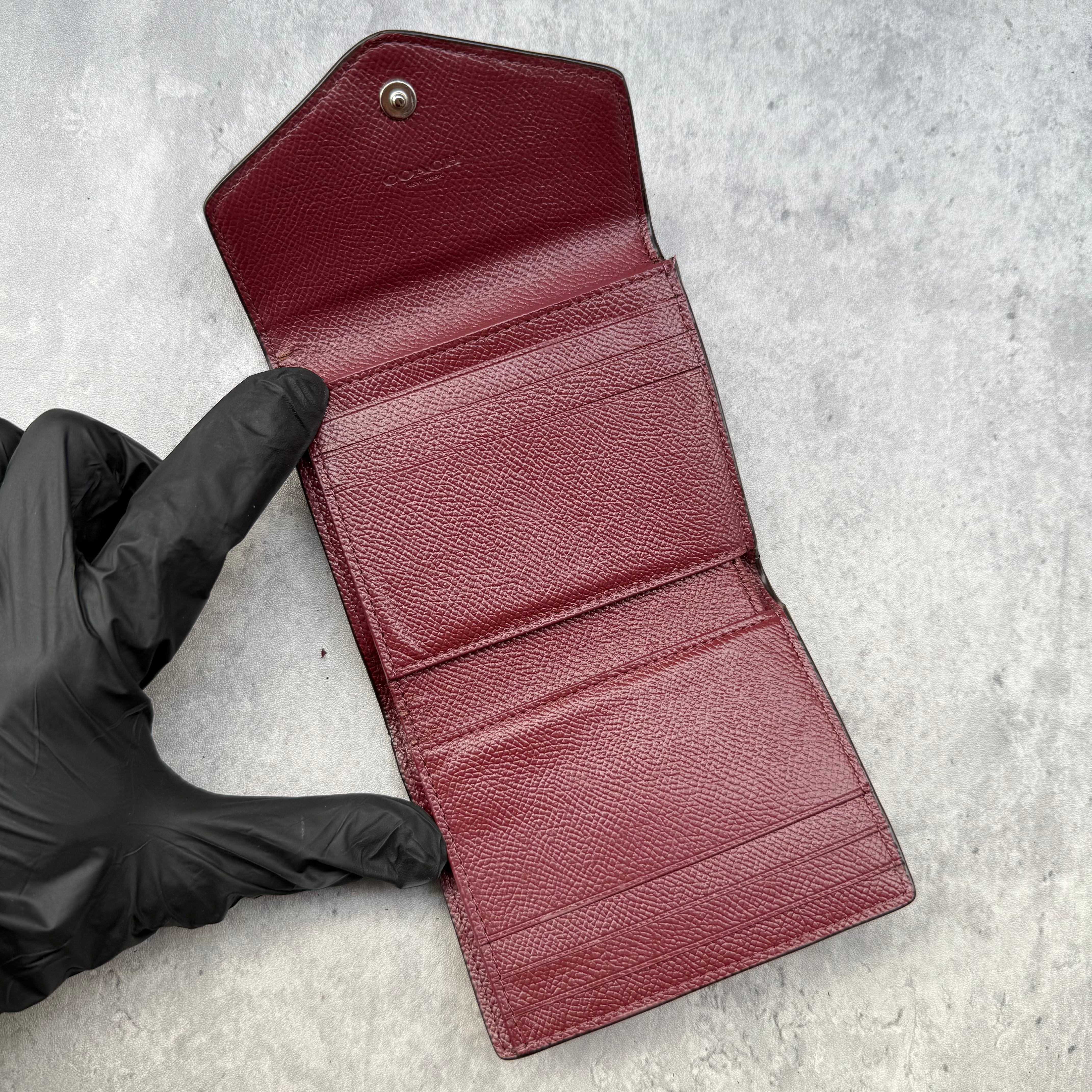 Coach Jasmine Colour-Block Small Wallet in plum, burgundy, and black pebbled leather with zip coin pocket