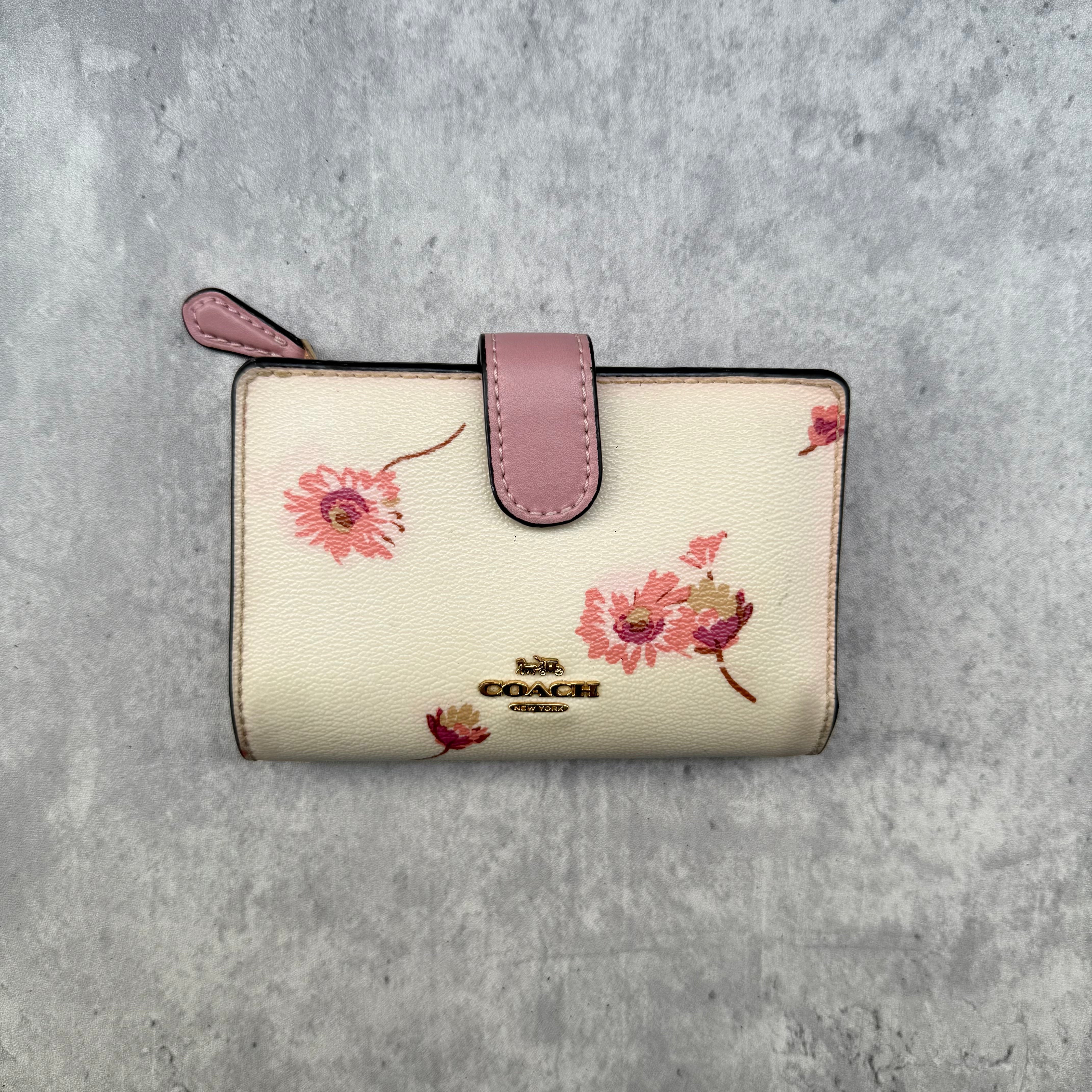 Coach Medium Corner Zip Wallet with multi floral print in ivory and pink, crafted from pebbled leather and featuring a snap tab closure and zip coin pocket.