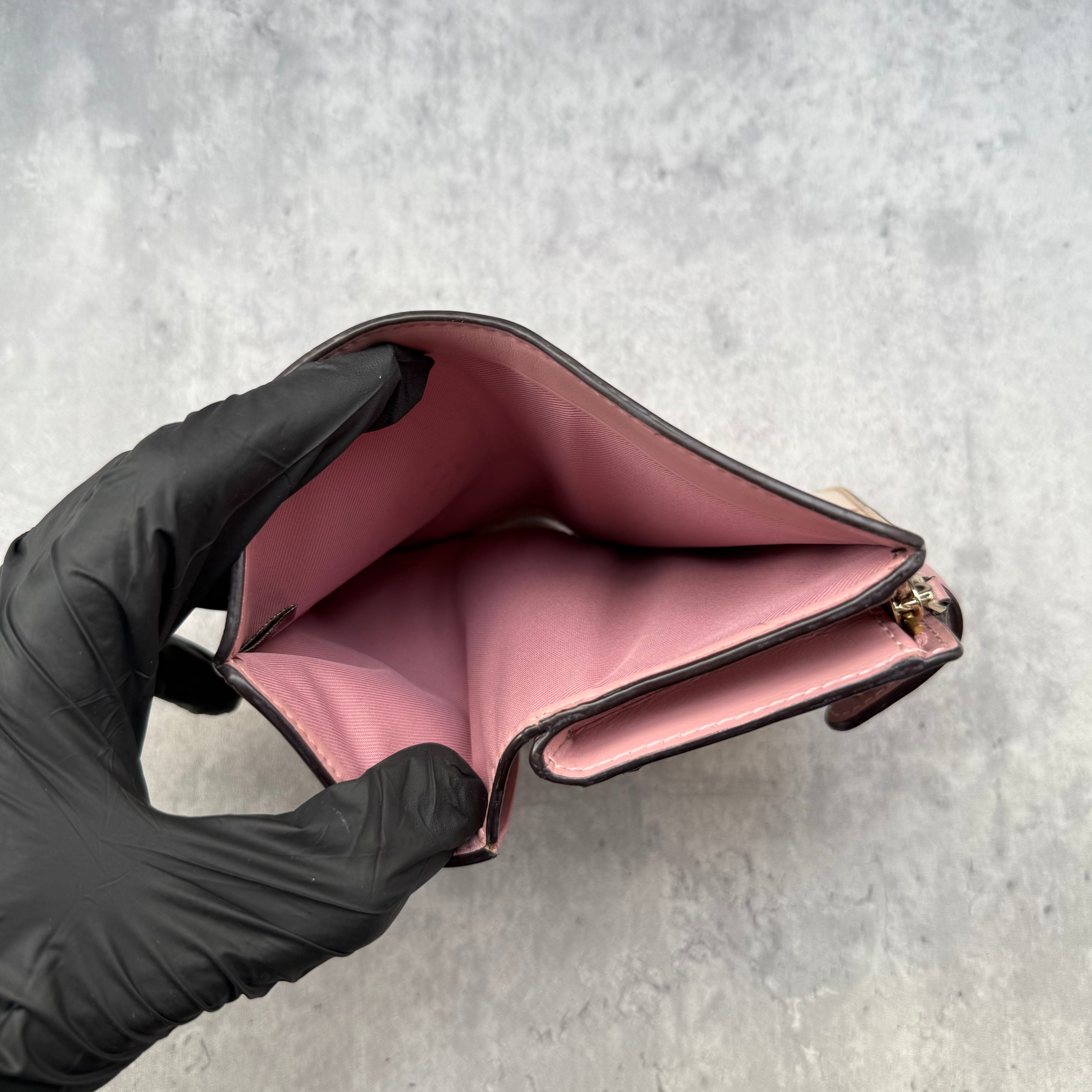 Coach Medium Corner Zip Wallet with multi floral print in ivory and pink, crafted from pebbled leather and featuring a snap tab closure and zip coin pocket.