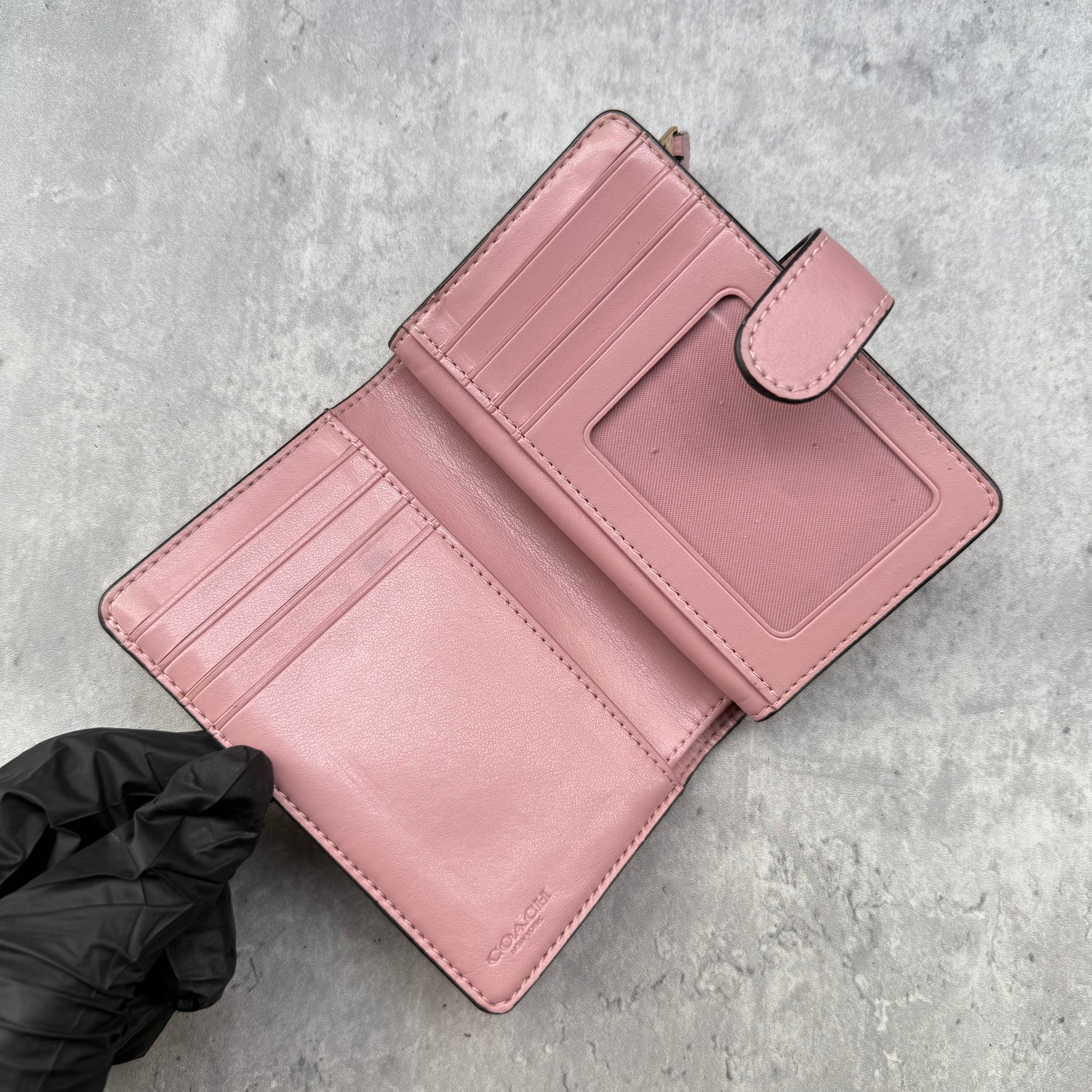 Coach Medium Corner Zip Wallet with multi floral print in ivory and pink, crafted from pebbled leather and featuring a snap tab closure and zip coin pocket.