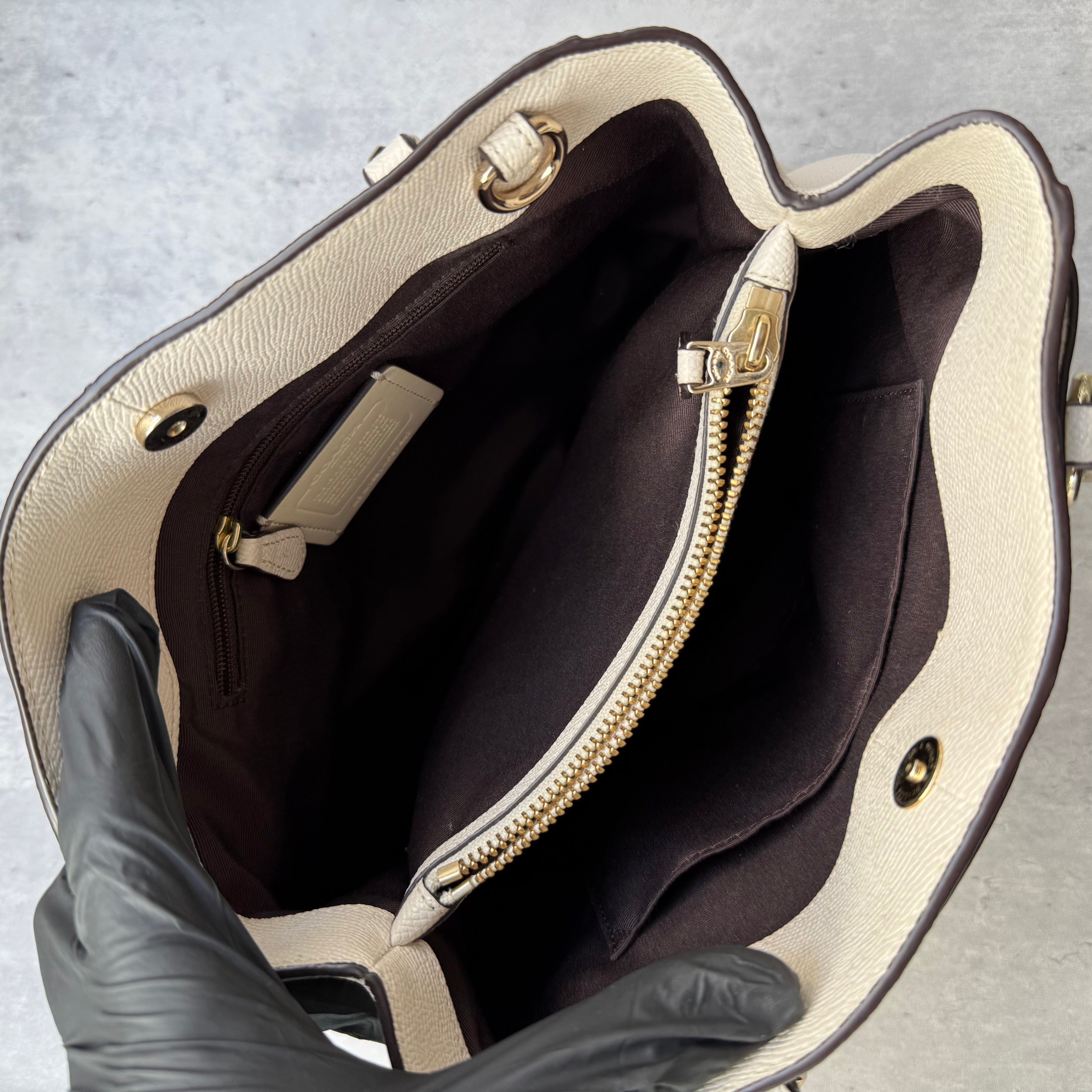 Coach Minetta Handbag in white pebbled leather with structured silhouette, top handles, and gold-tone logo